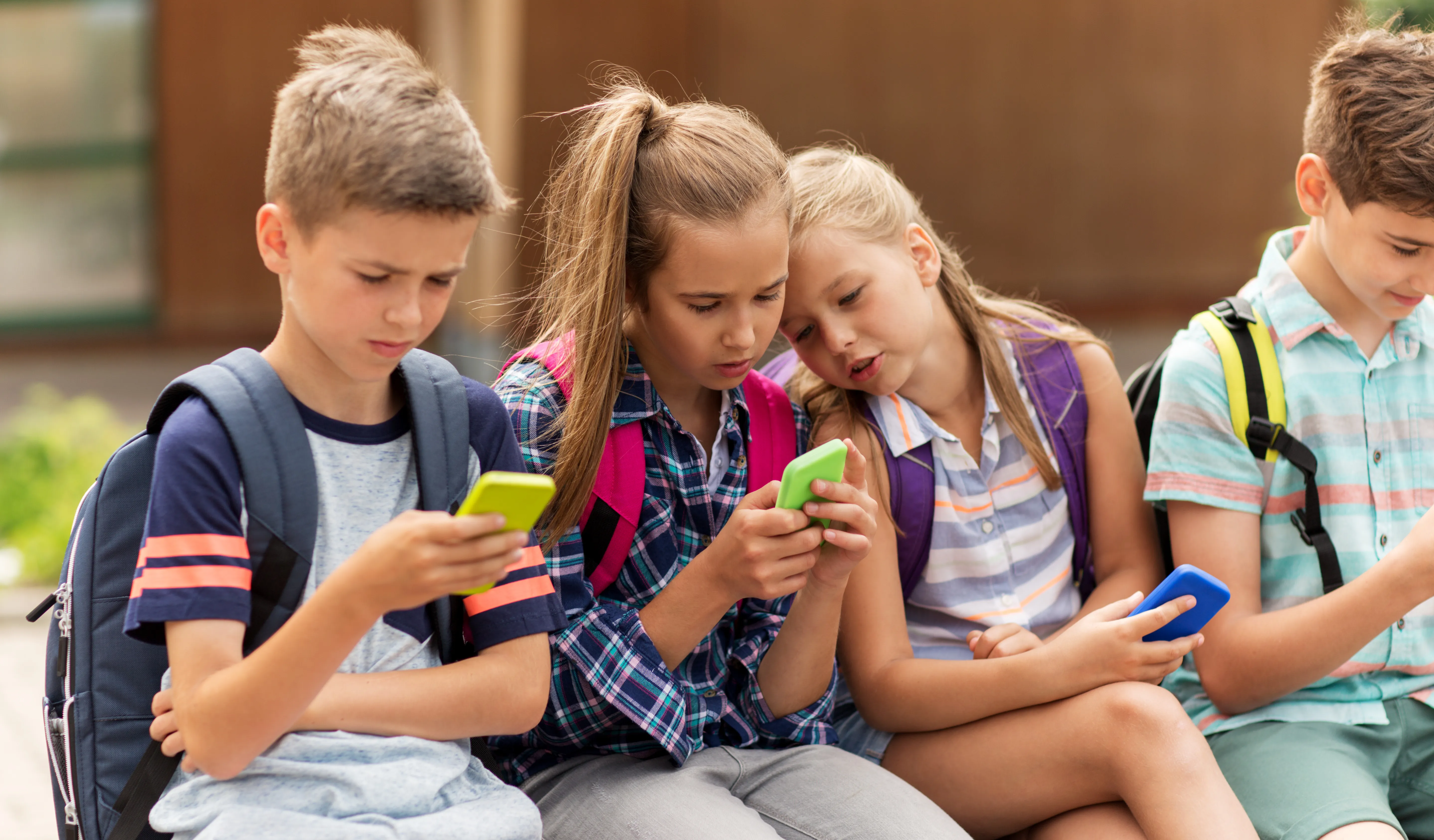 A group of children look at their phones.
