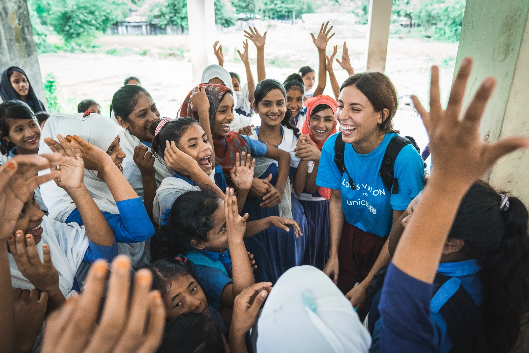 A Louis Vuitton staff member meets with children at a school in Nepal.