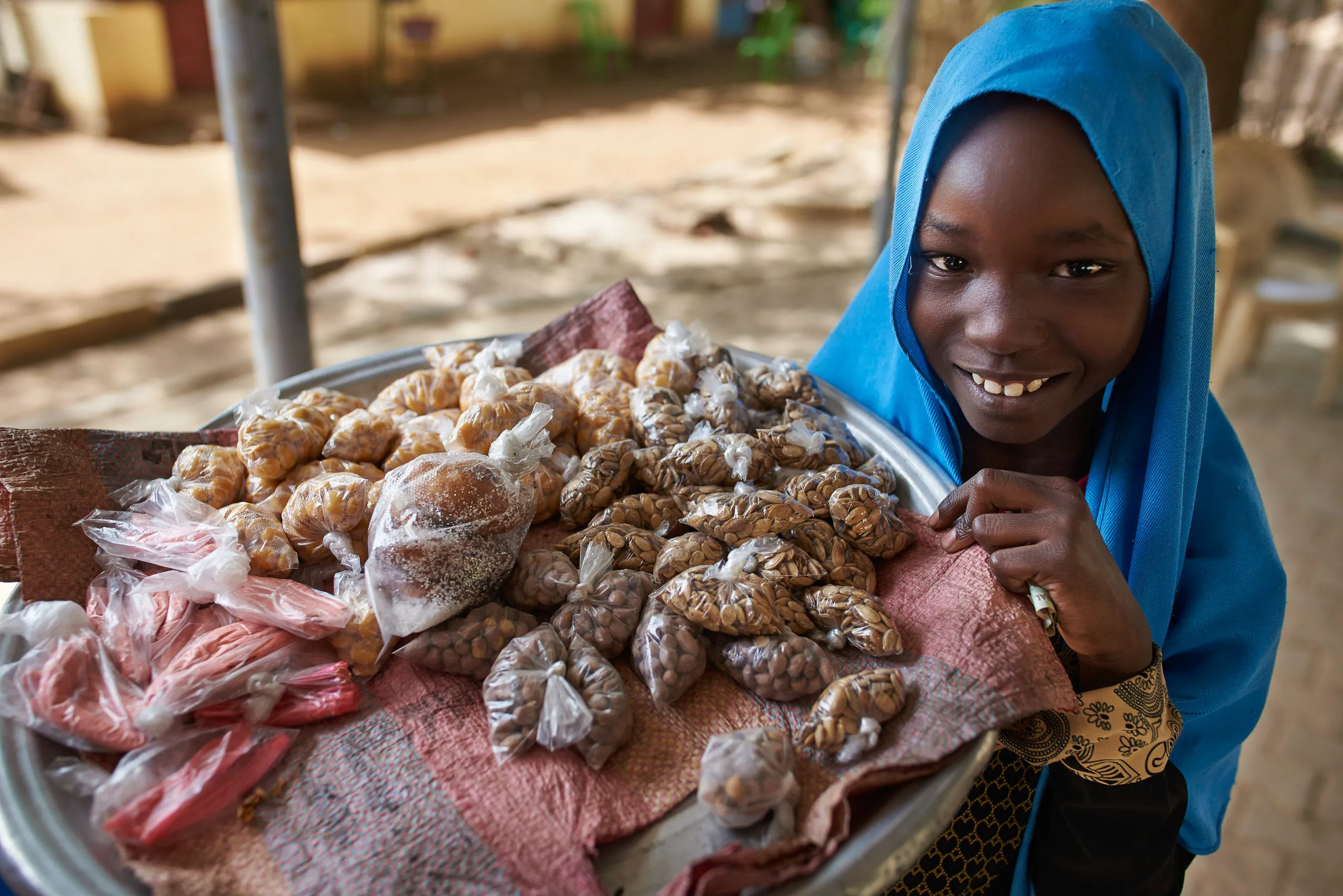 Girl smiling beside small plastic bags of food