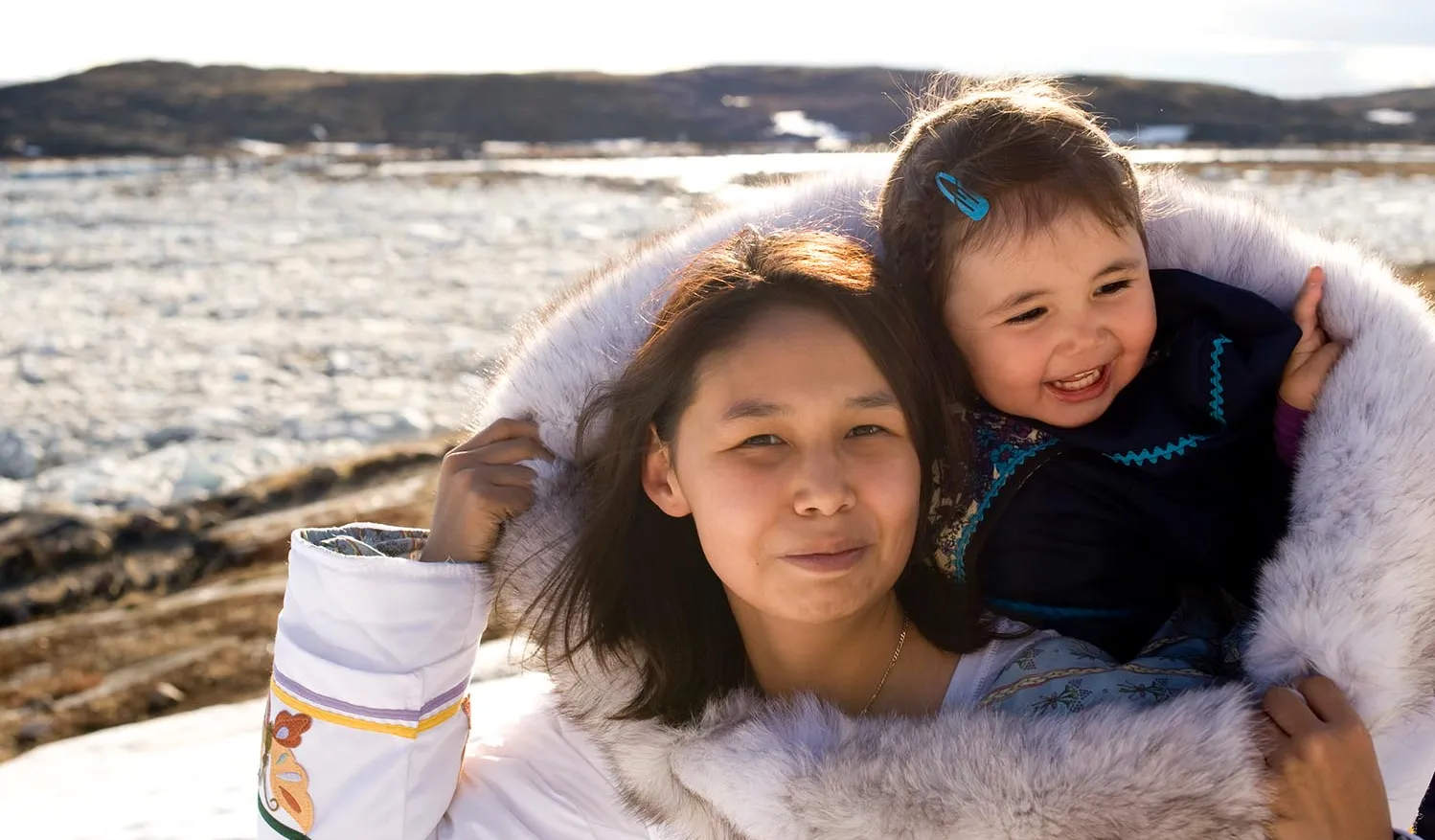 Une mère inuite porte son enfant dans son amauti.