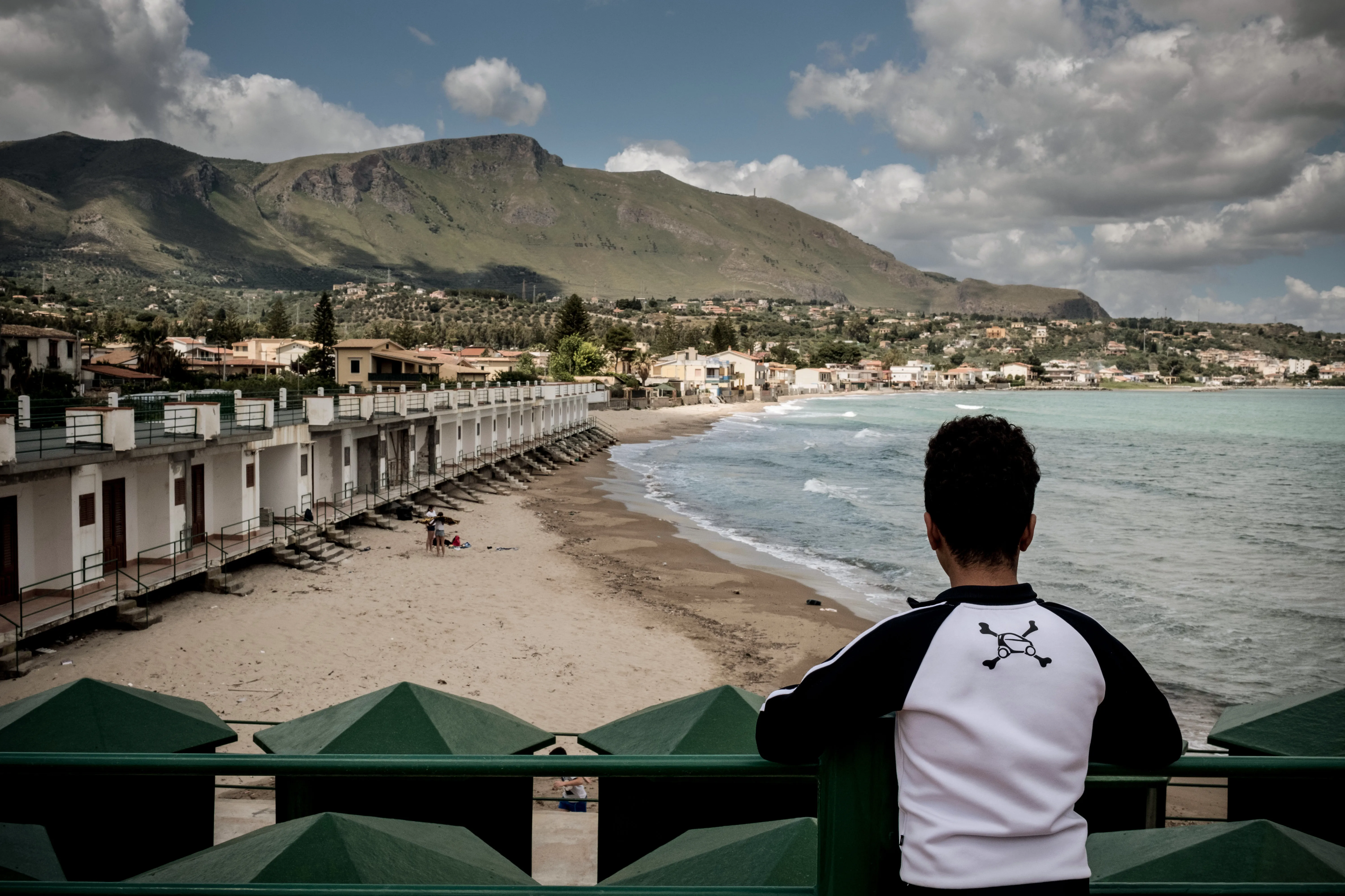 A boy who is an unaccompanied minor looks across the beach in Trabia, Italy, on May 14, 2016. 