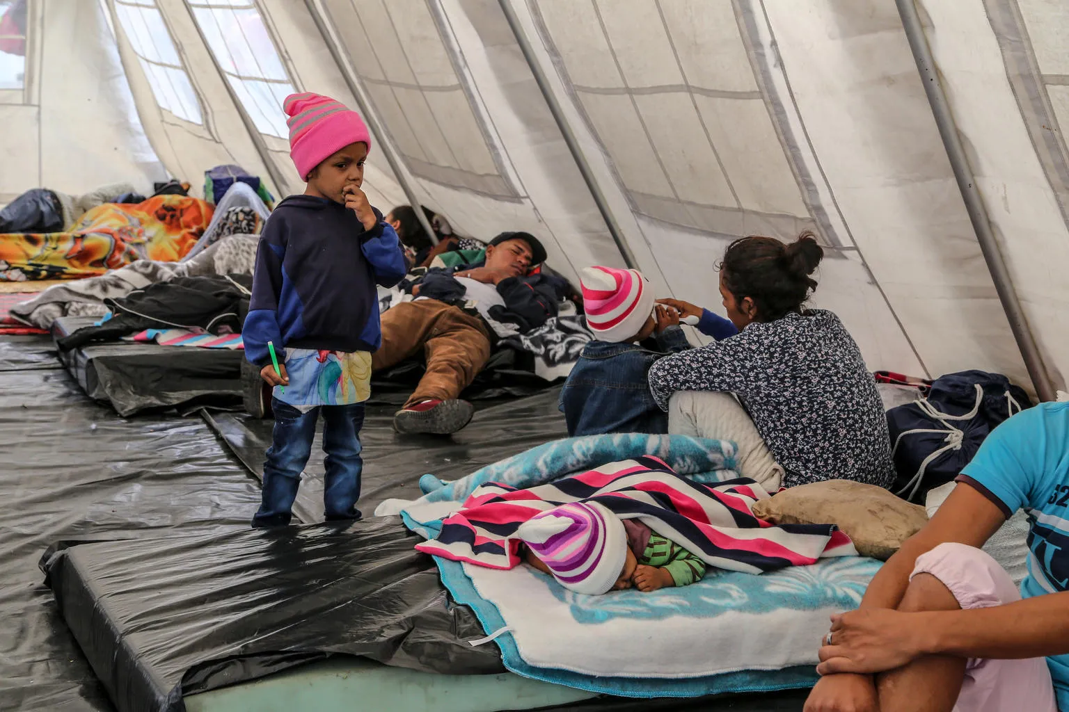 un enfant se tient dans une tente temporaire de l'UNICEF à Rumichaca, Équateur