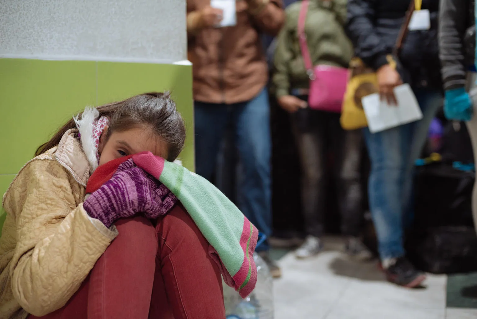 girl waits in line at Colombia Ecuador border