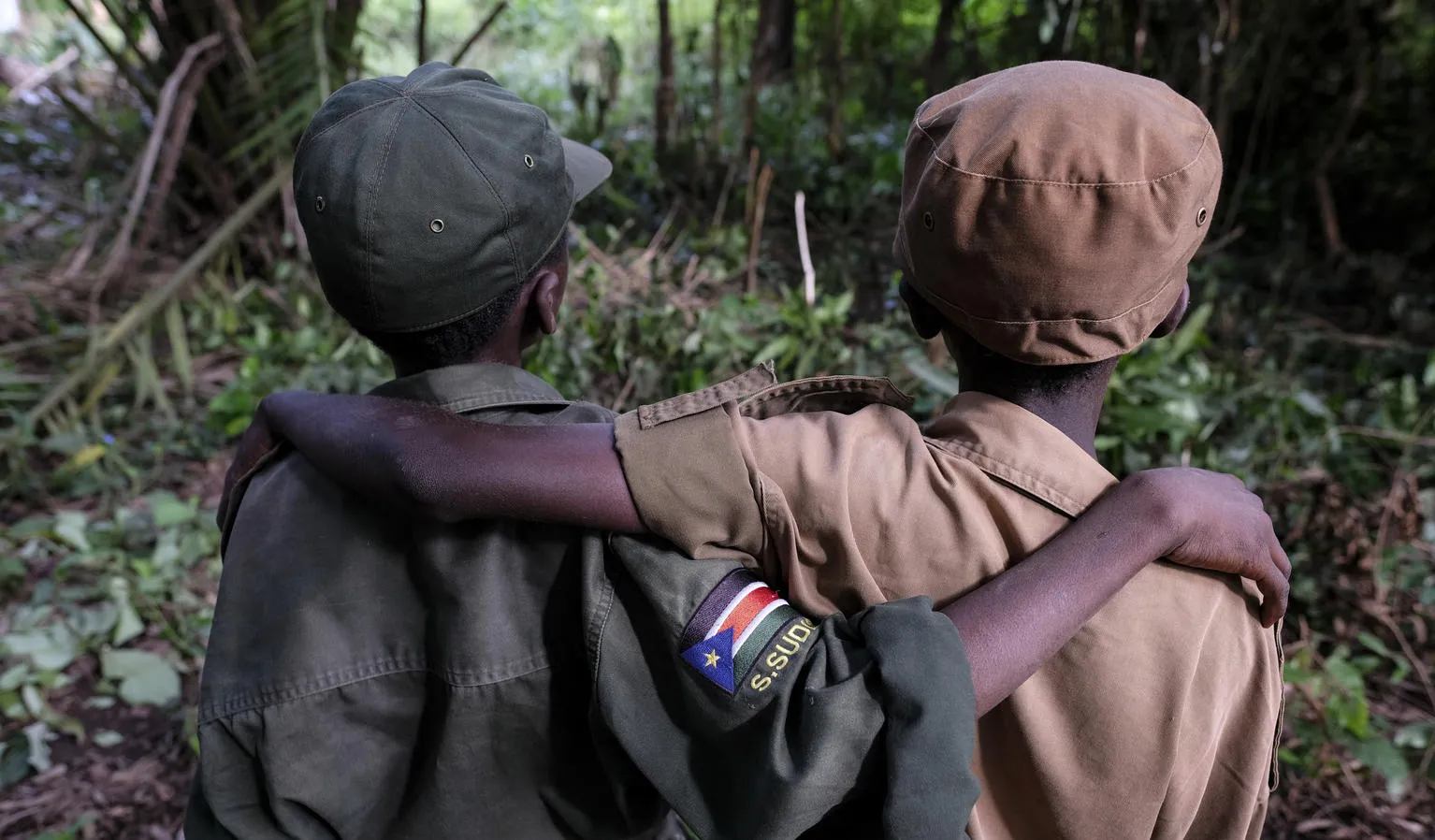 Two former child soldiers wait during a reintegration ceremony.