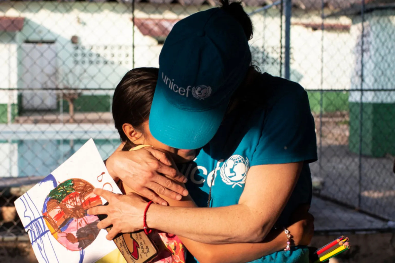 A UNICEF aid worker gives a hug to a Mexican girl.