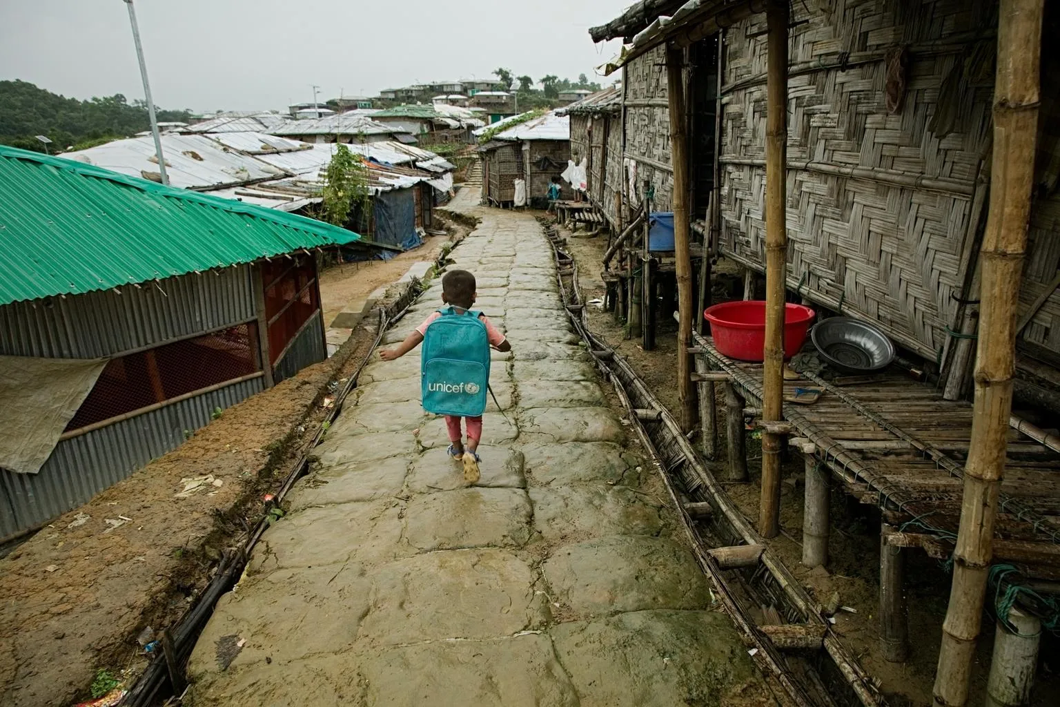 kid walk in rohingya camp during monsoon