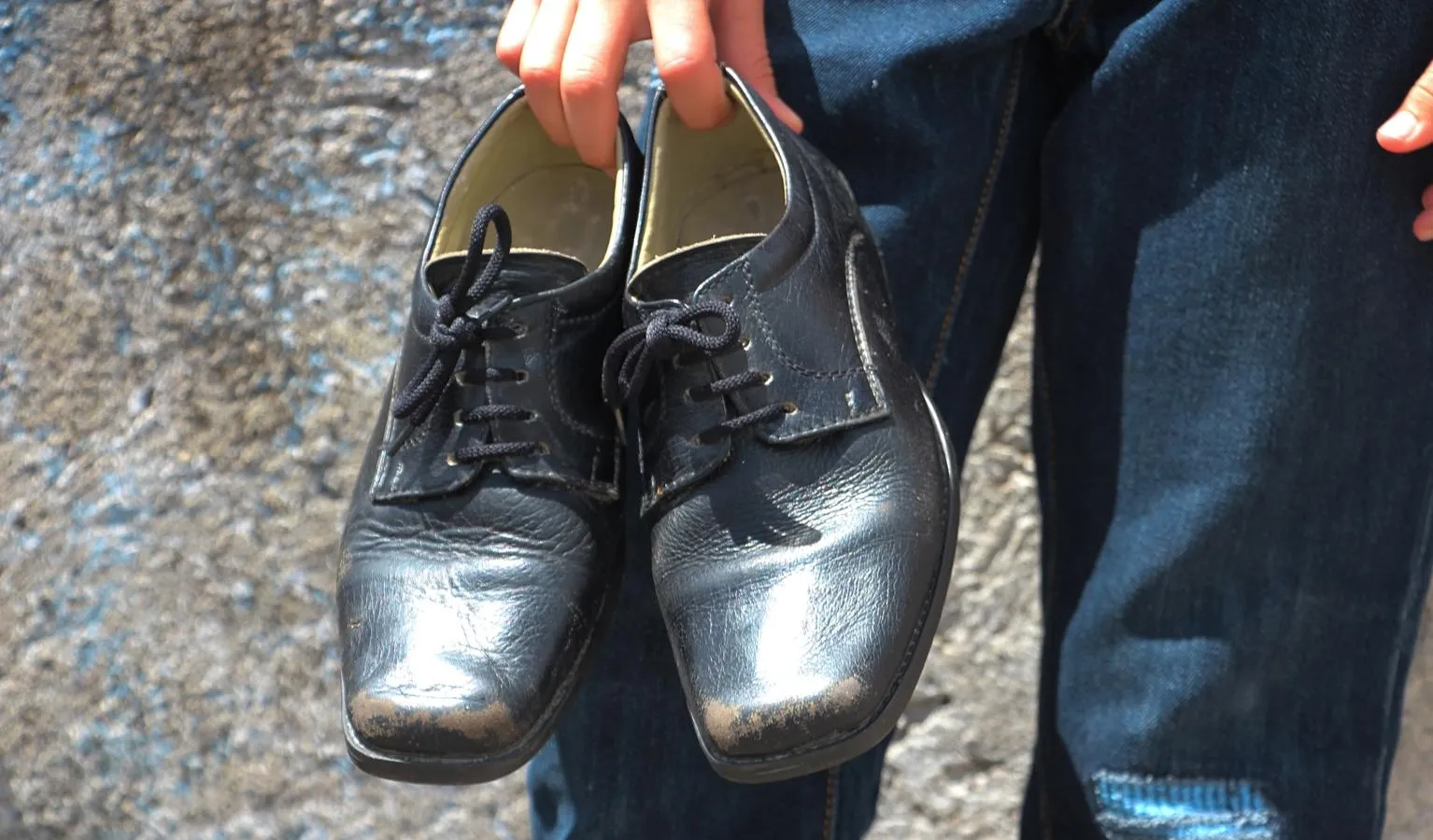 Angel Ganriel holds his new uniform shoes.