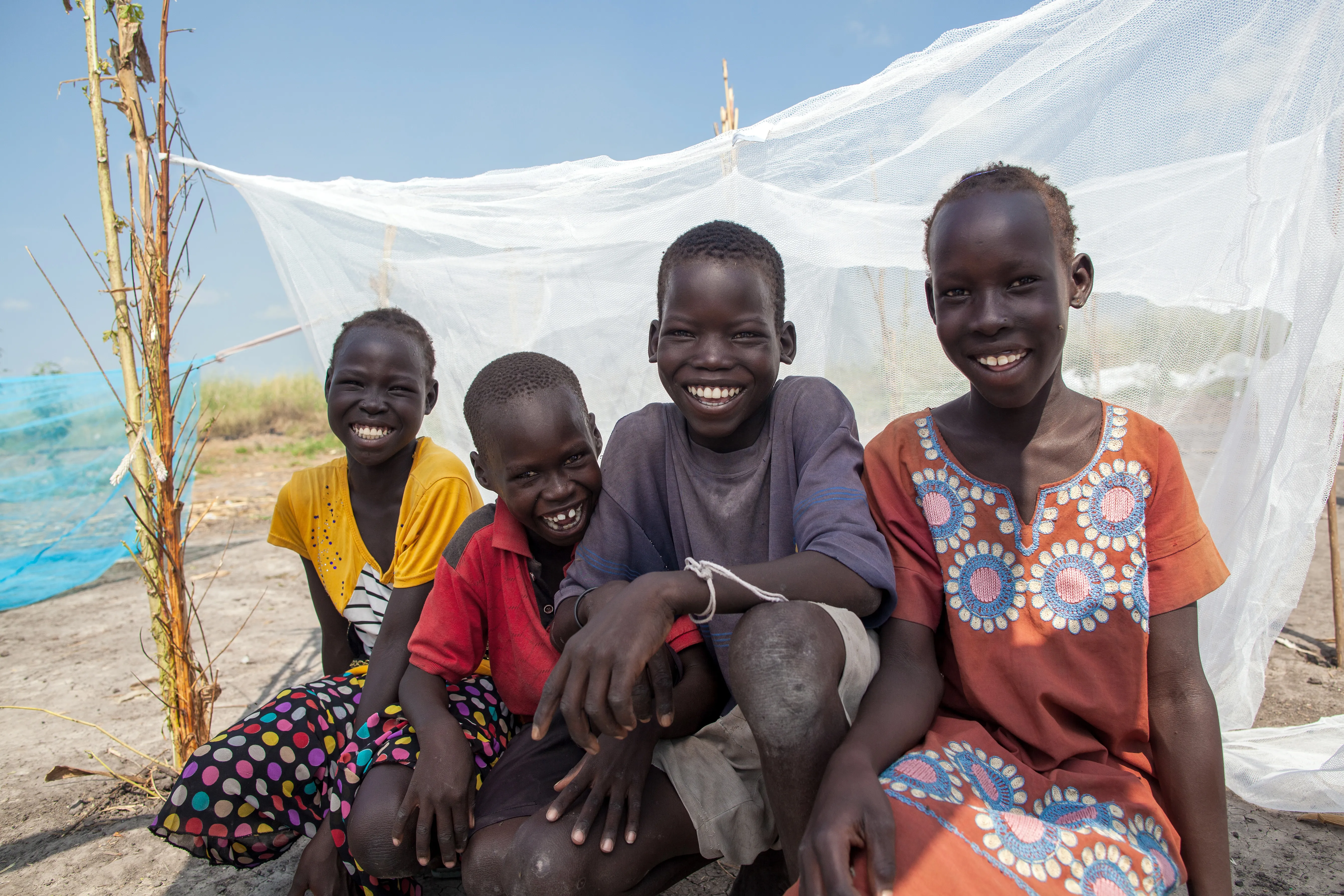 Friends sit by a UNICEF-supplied mosquito net in Bienythiang in Akoka county, Upper Nile state, South Sudan on 23rd October 2020.