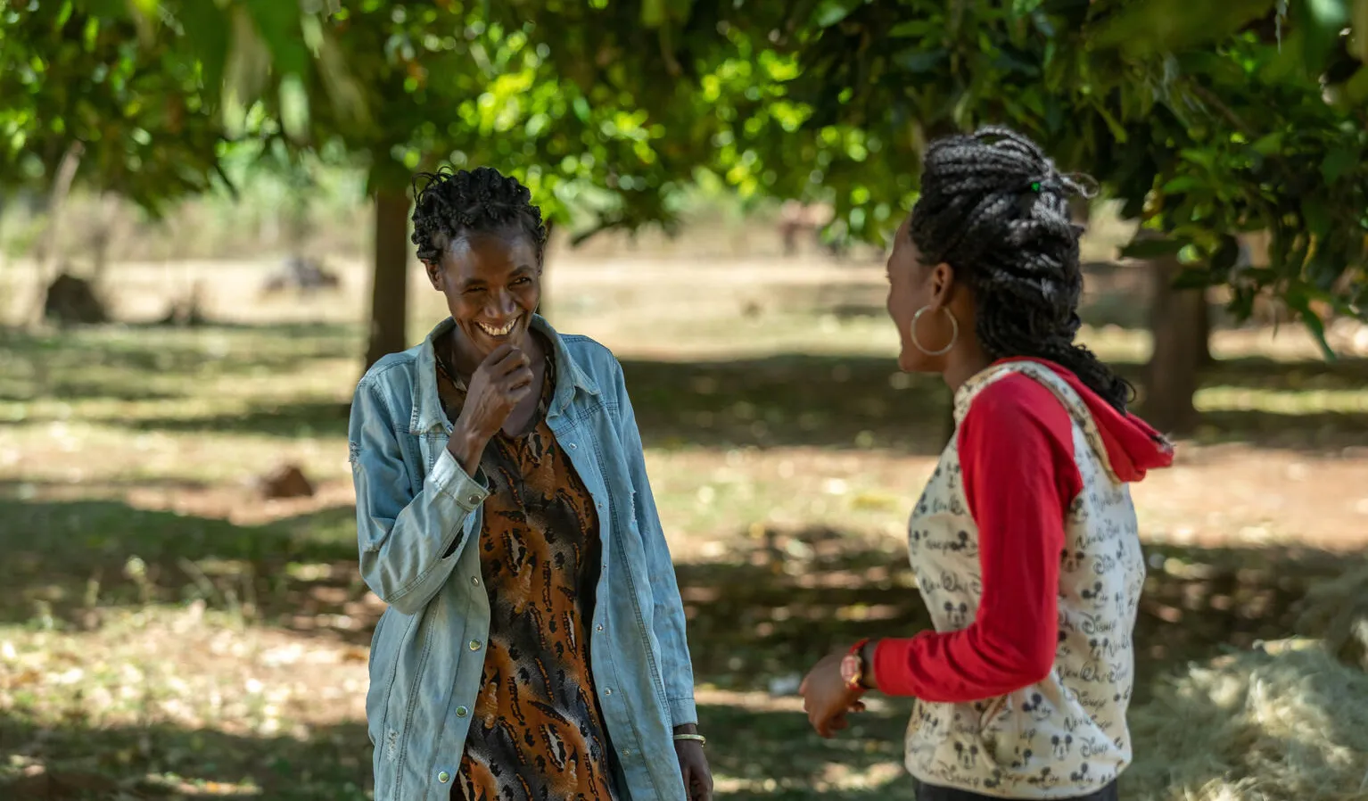 A woman and her daughter talk outside their home.