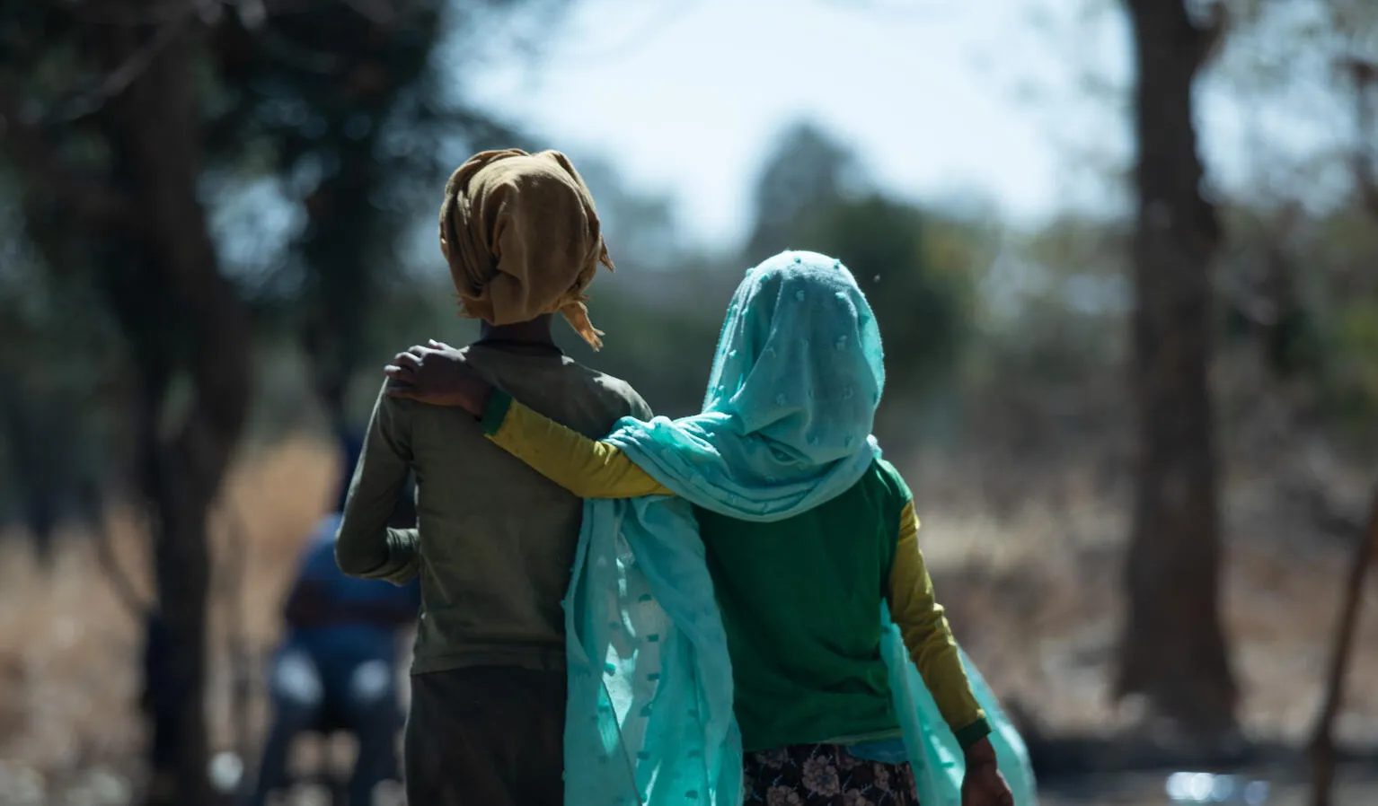 Two girls walk down a road in Ethiopia.