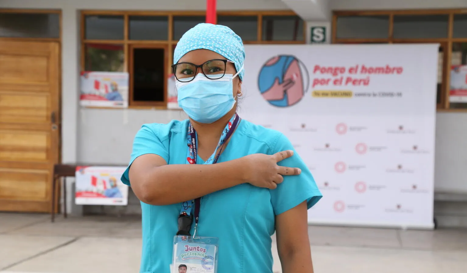 A health worker gives the V for Vaccinated sign after receiving their first COVID-19 vaccine in Peru.