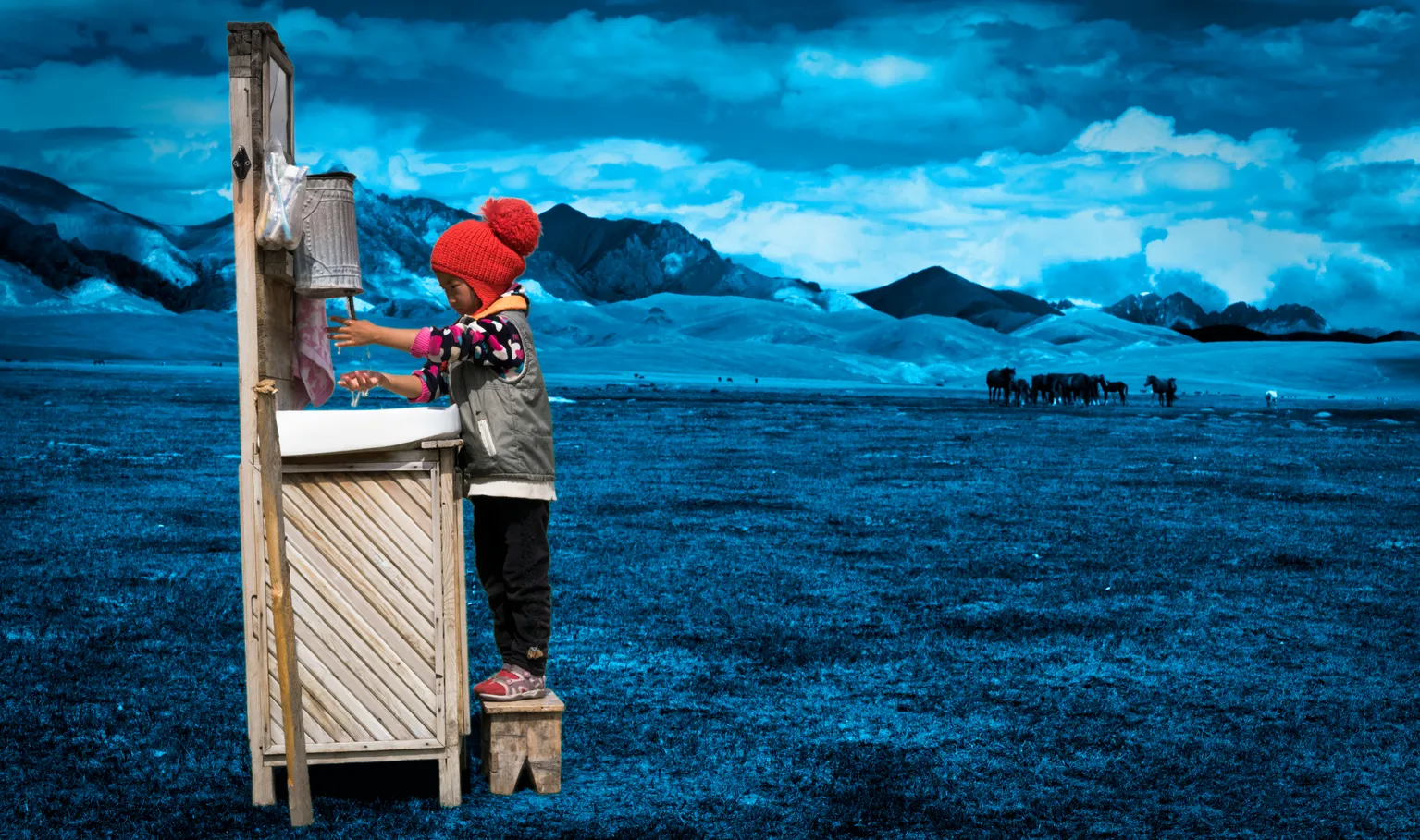 A child washes their hands at a portable station in Mongolia.