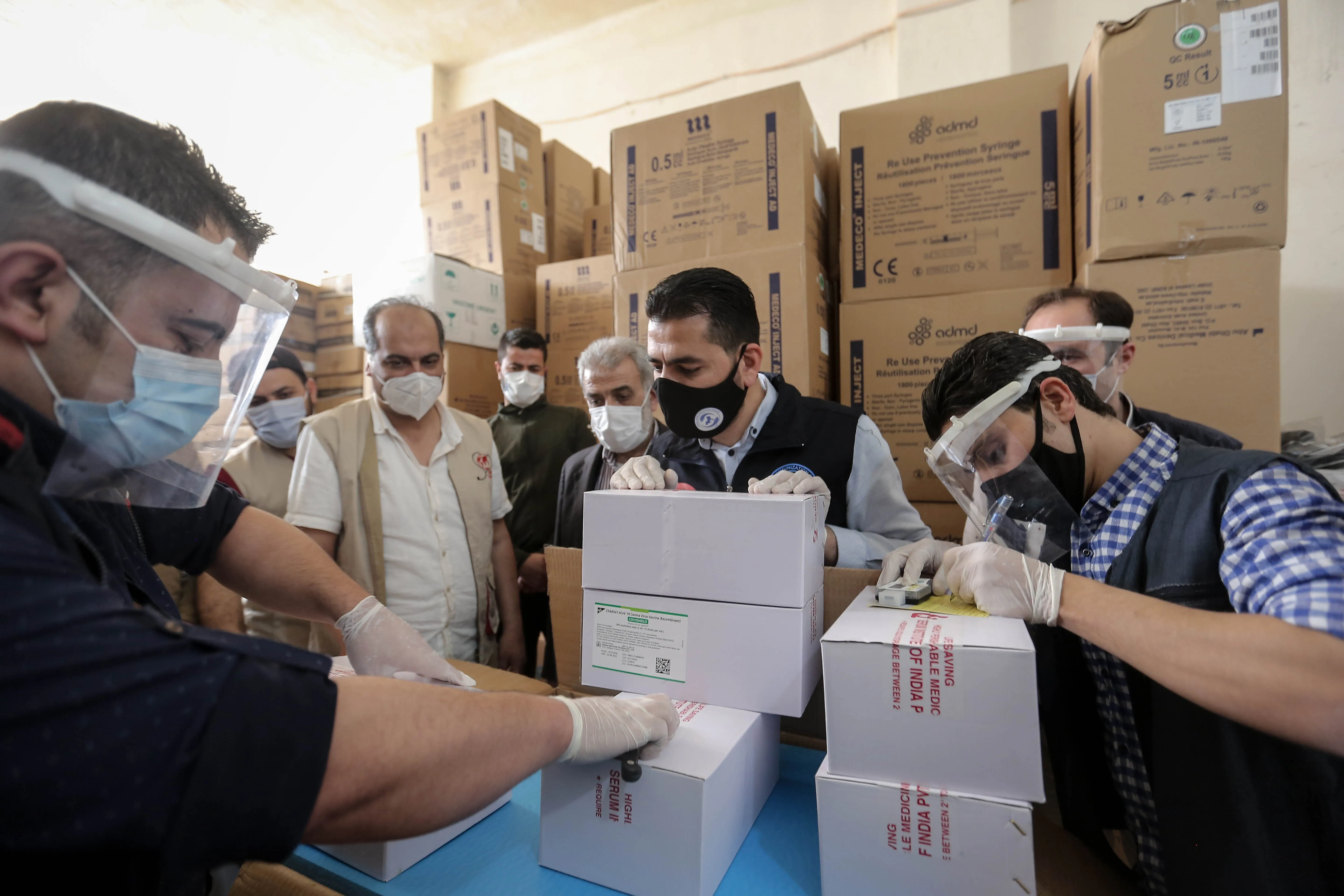 On 21 April 2021, staff members of UNICEF and WHO togerther with local partners, inspect the first shipment of COVID-19 vaccines for the COVAX Facility in Jdaydet Yabous, a village situated on the border between Syria and Lebanon, in the rural area of Damascus.