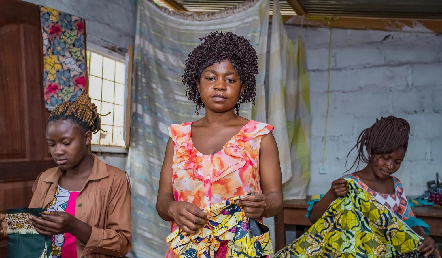Students pose together at the sewing studio.
