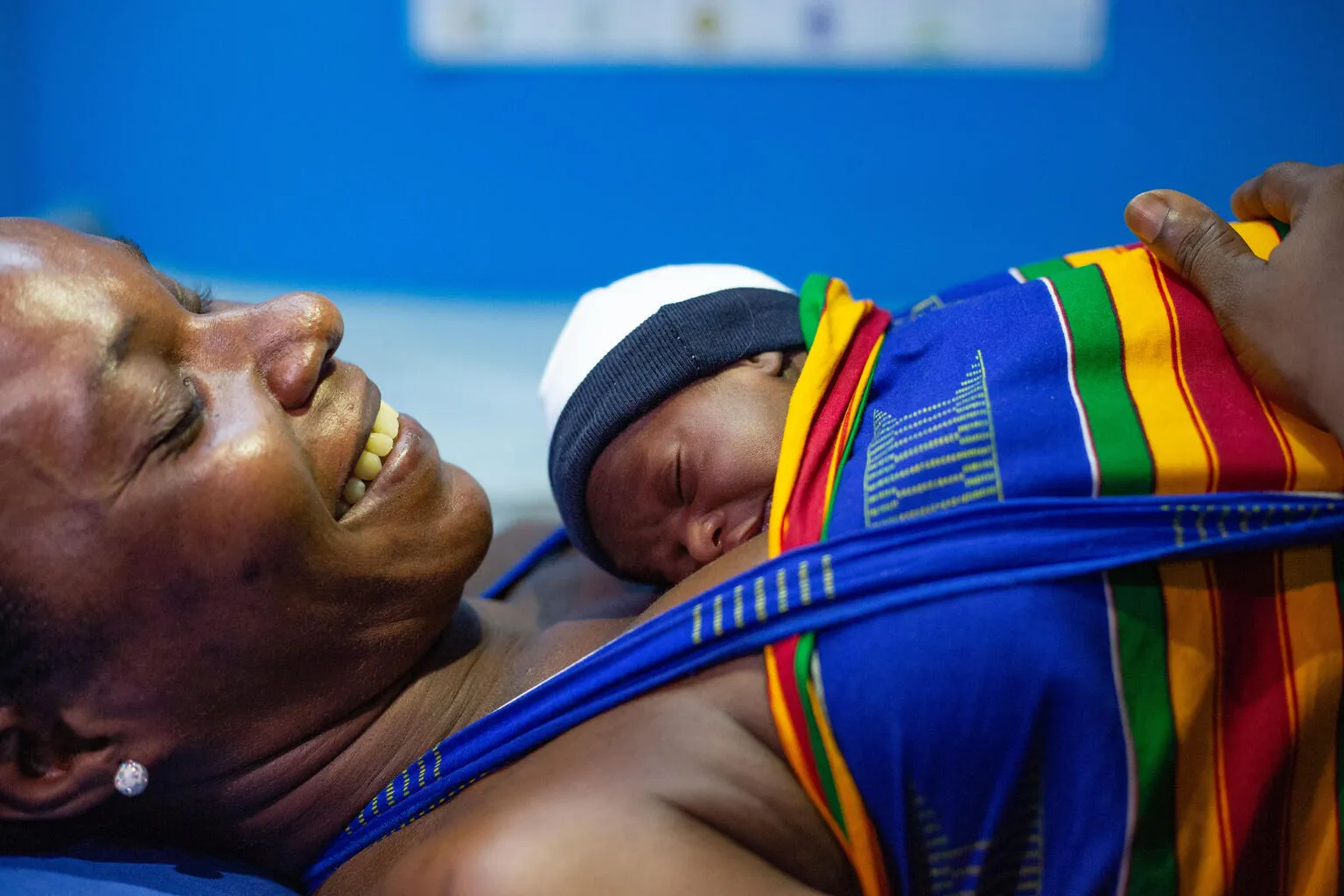 A mother practices kangaroo care with her newborn baby at a hospital.