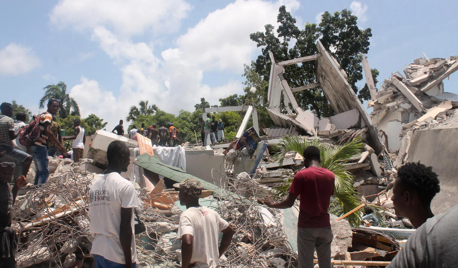 Les gens fouillent les décombres de ce qui était l'hôtel Manguier après le tremblement de terre en Haïti.