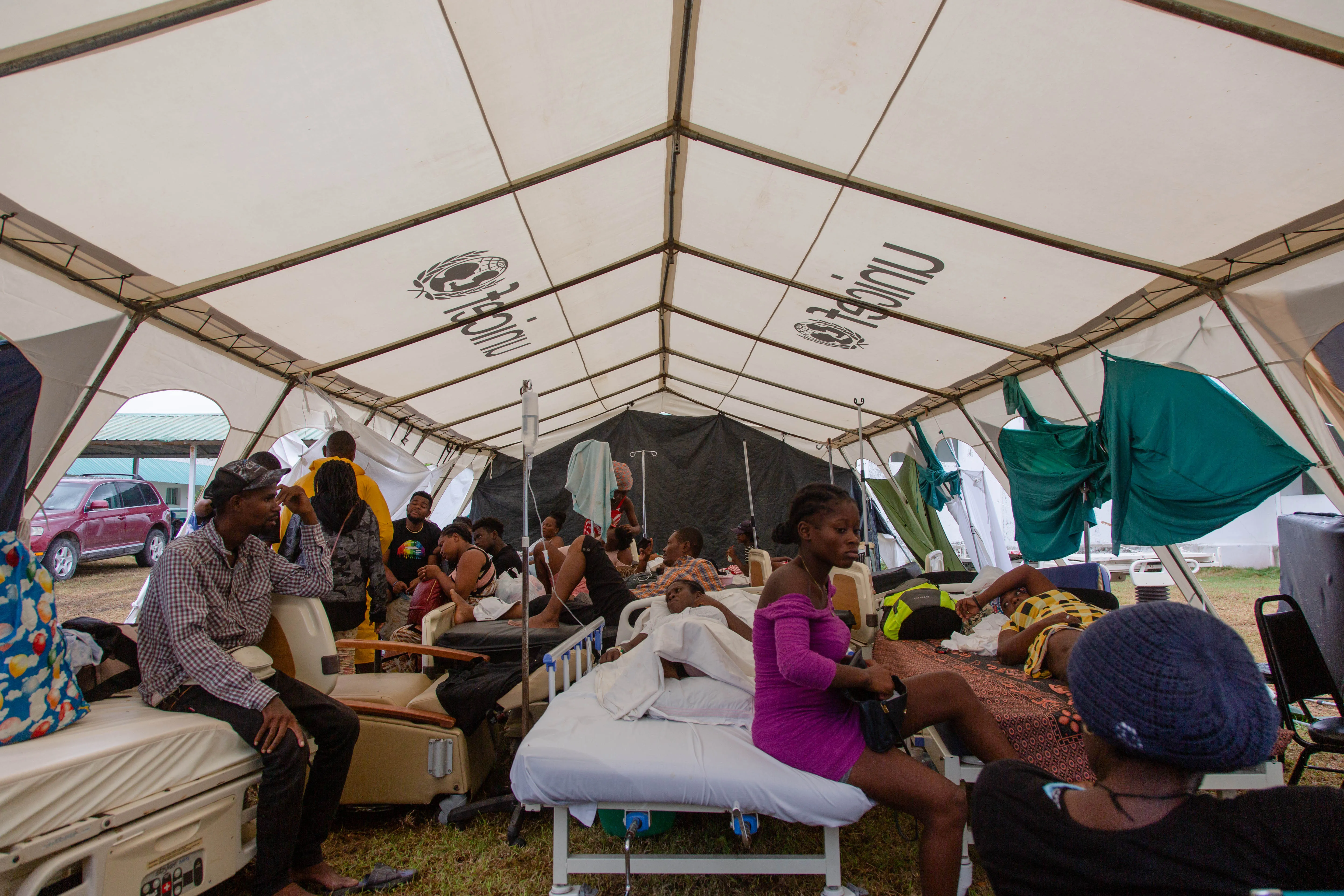 On 17 August 2021, patients of Ofatma Hospital in Les Cayes, Haiti and their families wait for medical attention in a UNICEF-supplied tent in the hospital's courtyard. UNICEF installed the tents to shelter patients who feared the hospital building could collapse.