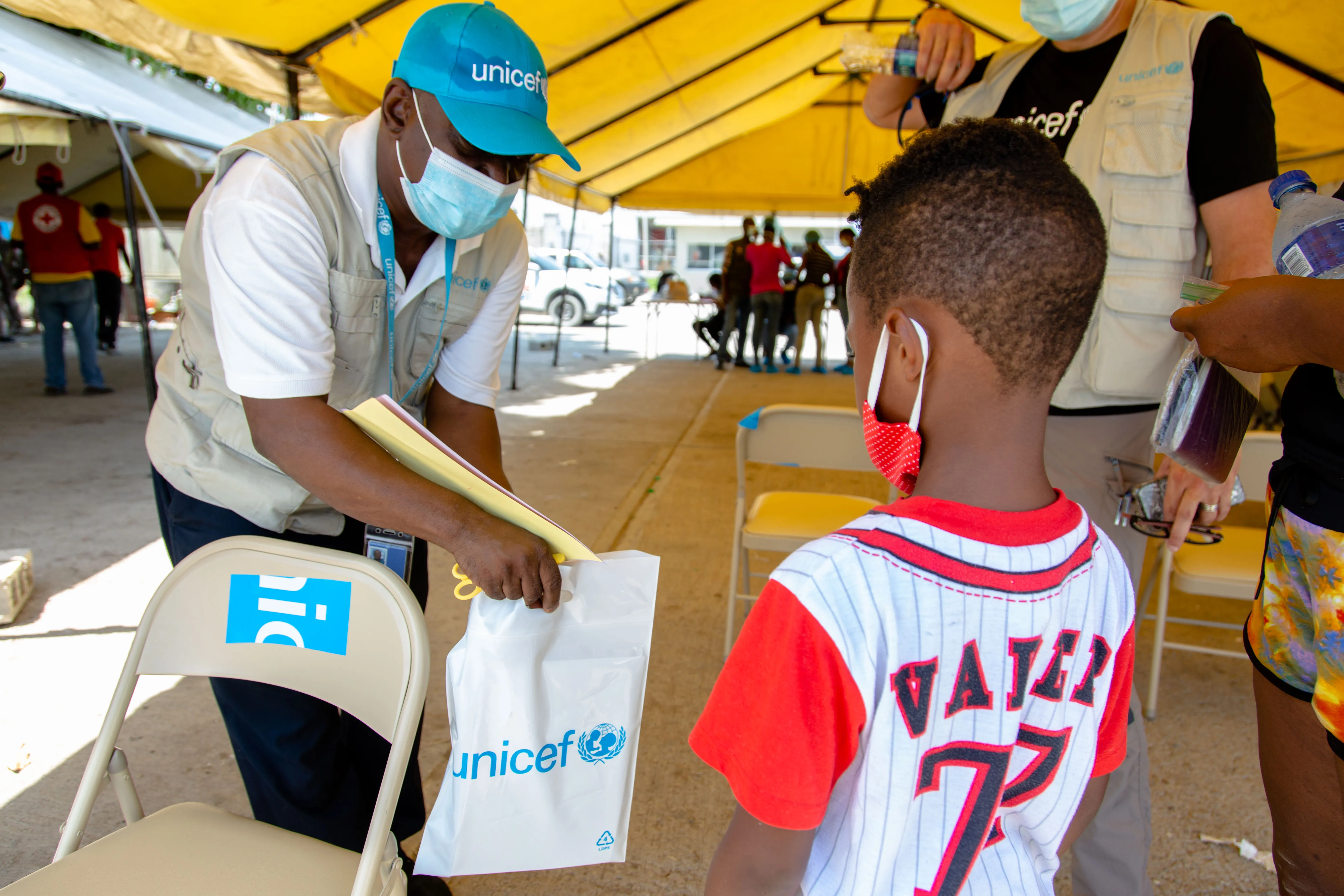 Marc receiving an education kit from UNICEF staff at the Port au Prince airport upon his arrival in Haiti.23 September 2021 – Port au Prince Airport, Haiti. Haitian families being expelled from the United States border to Haiti through several flights during the day.  UNICEF is on the ground at the airport and provides returning children with psychosocial support, protection services and education supplies, in coordination with national authorities and the International Organization for Migration.  