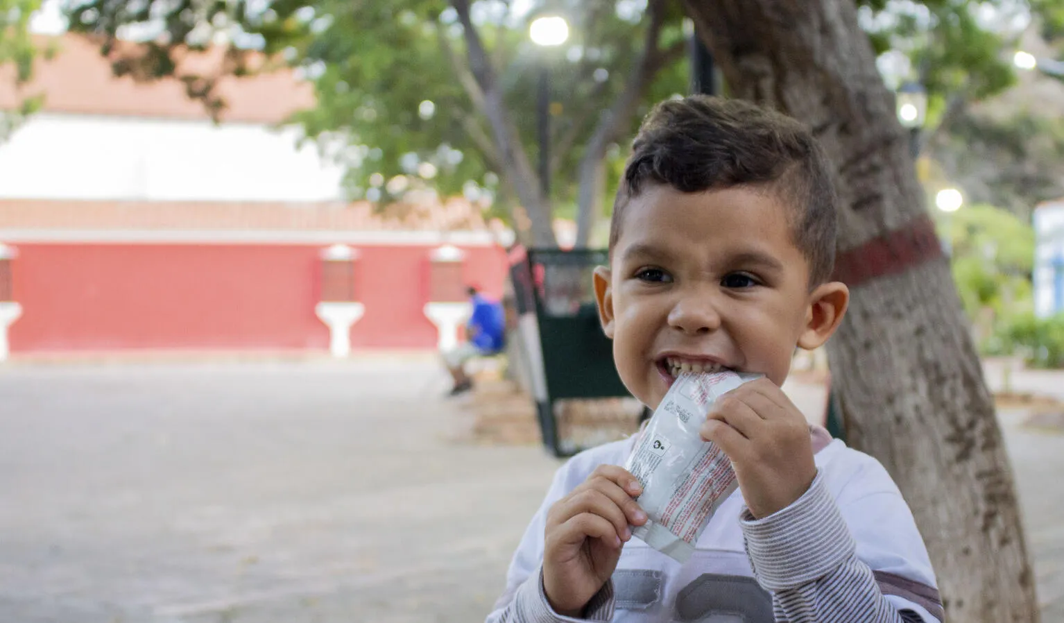 A child eats from a packet of ready-to-use therapeutic food in Venezuela.