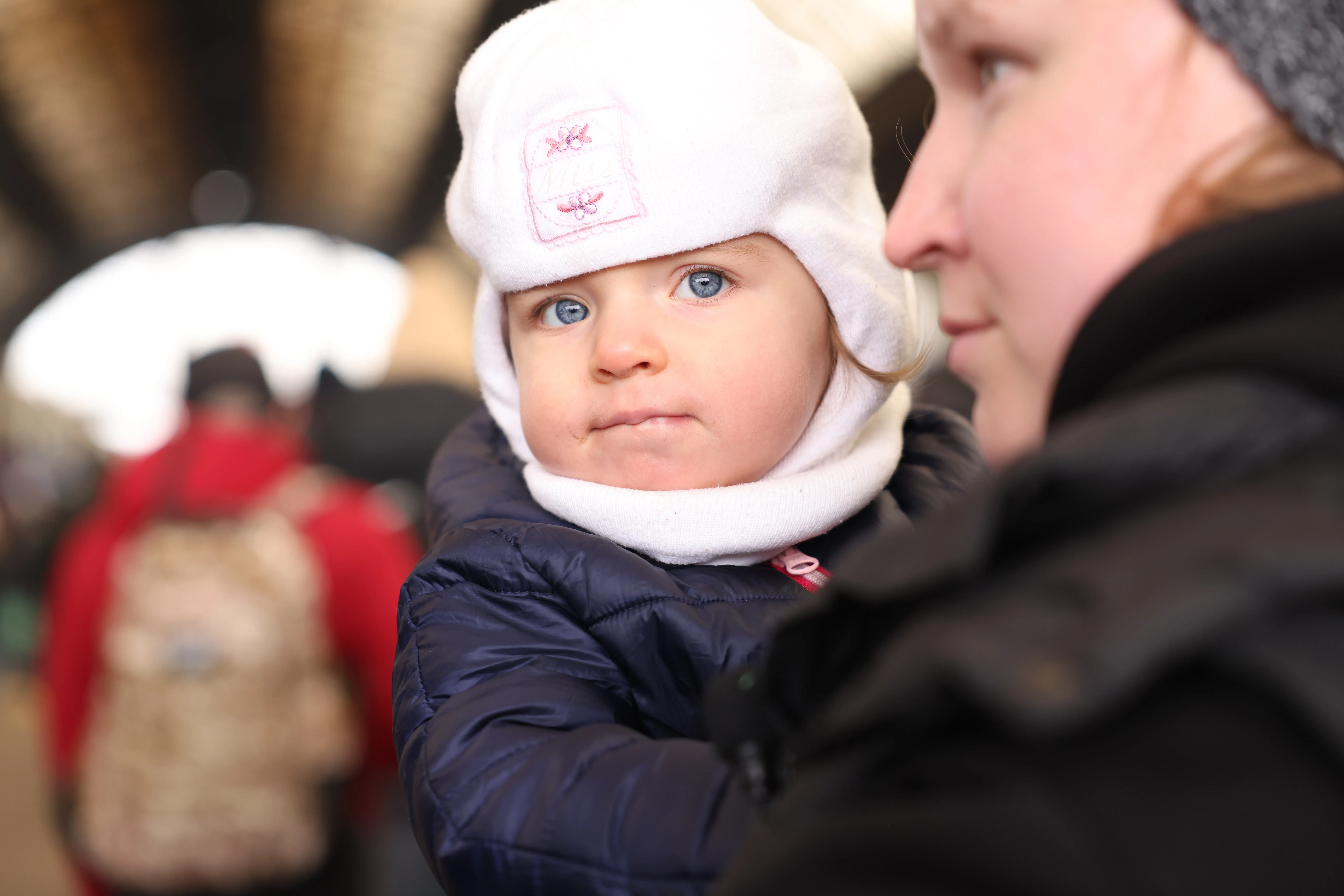 On 27 February 2022, as military operations continue in Ukraine, a woman carrying a small child waits to board an evacuation train at the railway station in Lviv, in Ukraine's westernmost corner, near the Polish border.