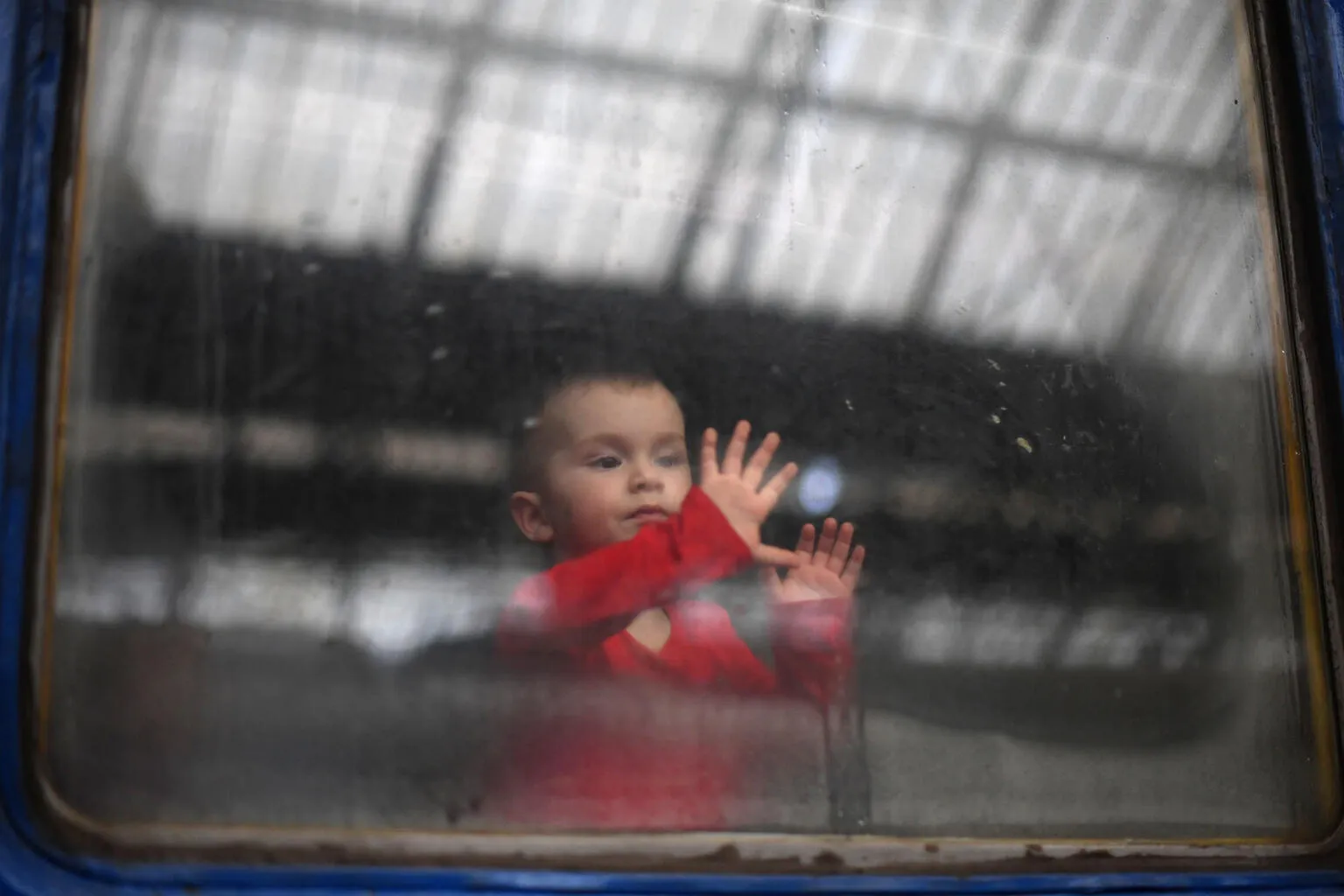 A child looks out from a carriage window