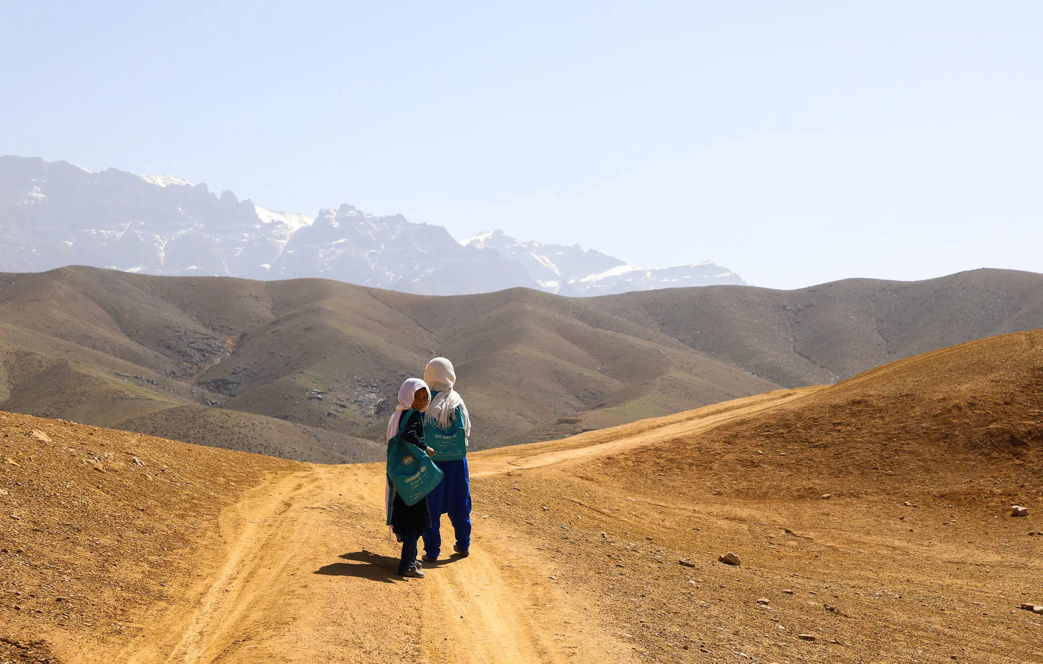 The students of Warkak's accelerated learning center in Daikundi Province walk home together over the dusty hills.