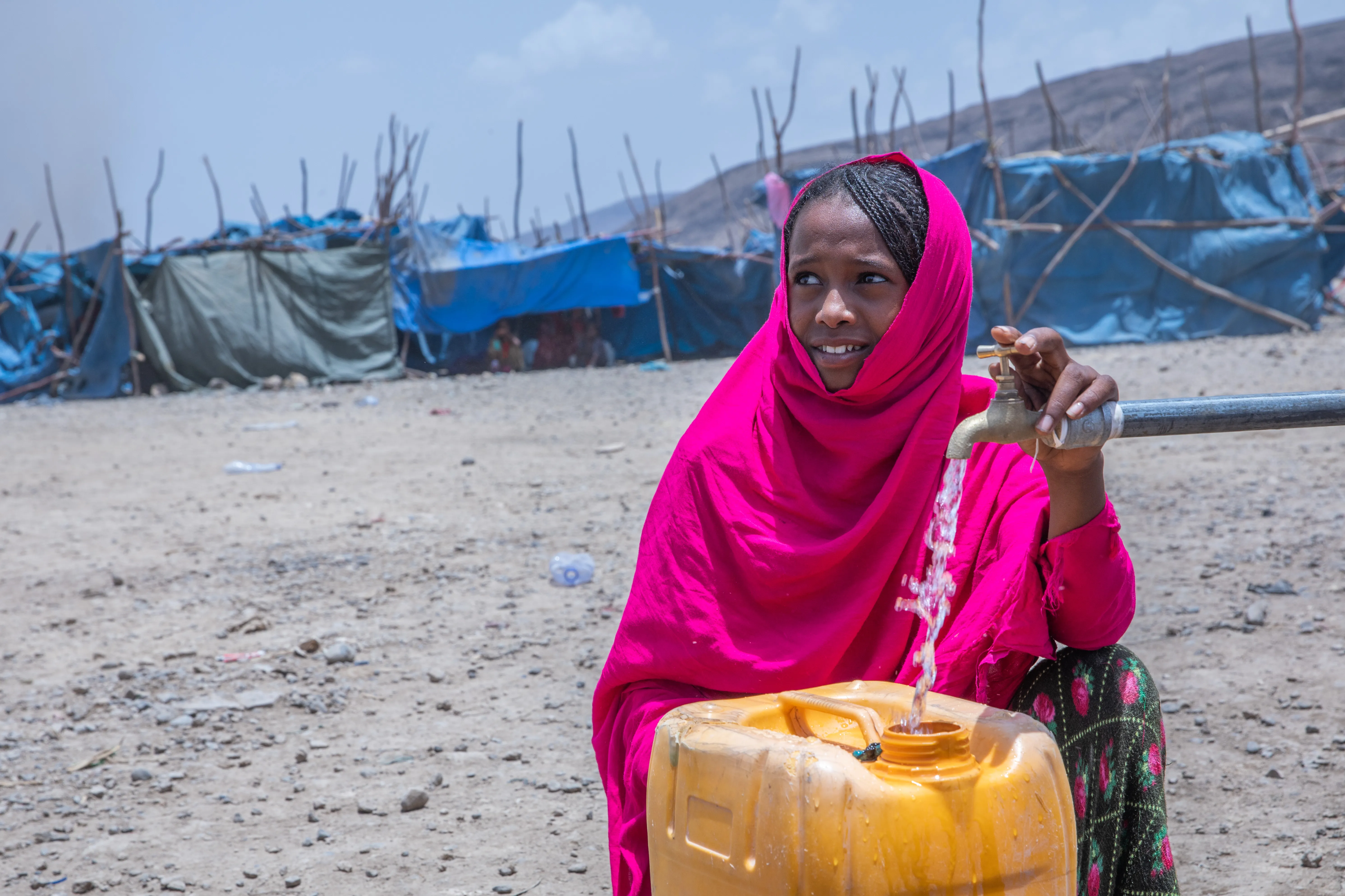 On 10 May 2022 in the internally displaced person (IDP) site of Guyah, Afar Region, Ethiopia, 13-year-old Keria fetches water from a UNICEF supported water point.