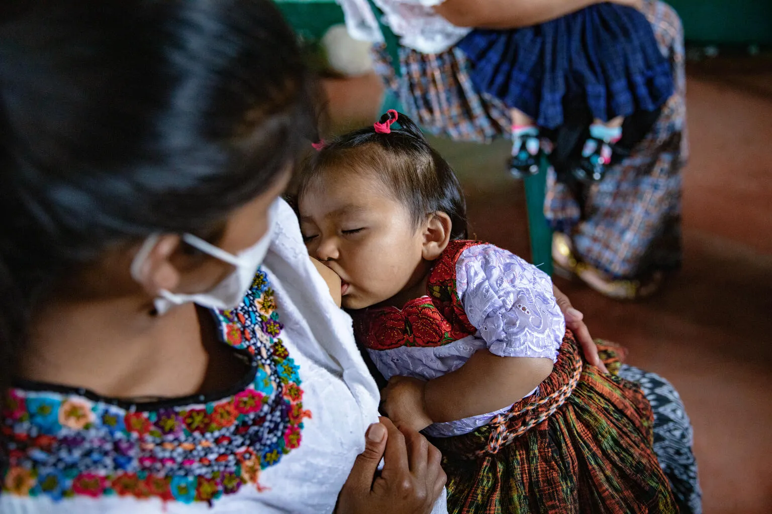 A woman breastfeeds a child.