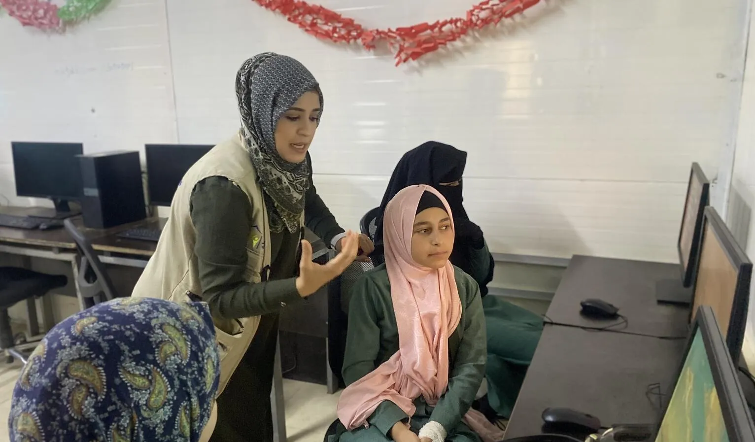 Hanadi teaches Syrian children computer skills at a UNICEF Jordan supported Makani center in Za’atari refugee camp.