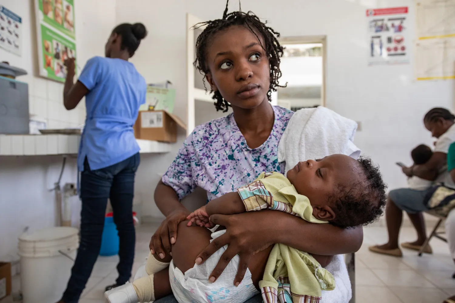 A woman is holding a child in her arms.