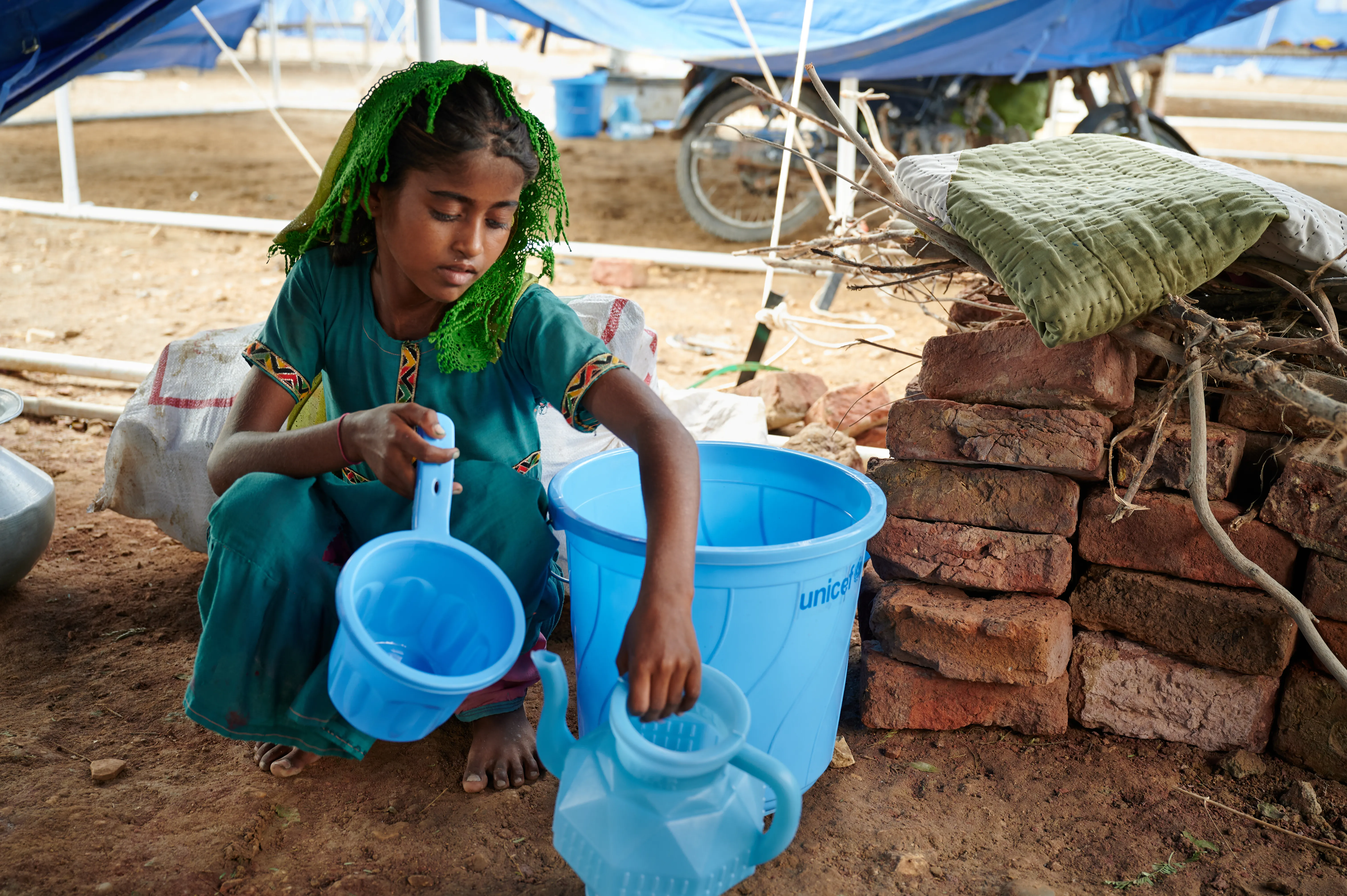 On 14 September 2022, sitting on floor of her shared tent, Geetu, 8 years old, shows off a hygiene kit her family received from UNICEF at Mohammad Medical Emergency Camp in Umerkot District, Sindh Province, Pakistan.