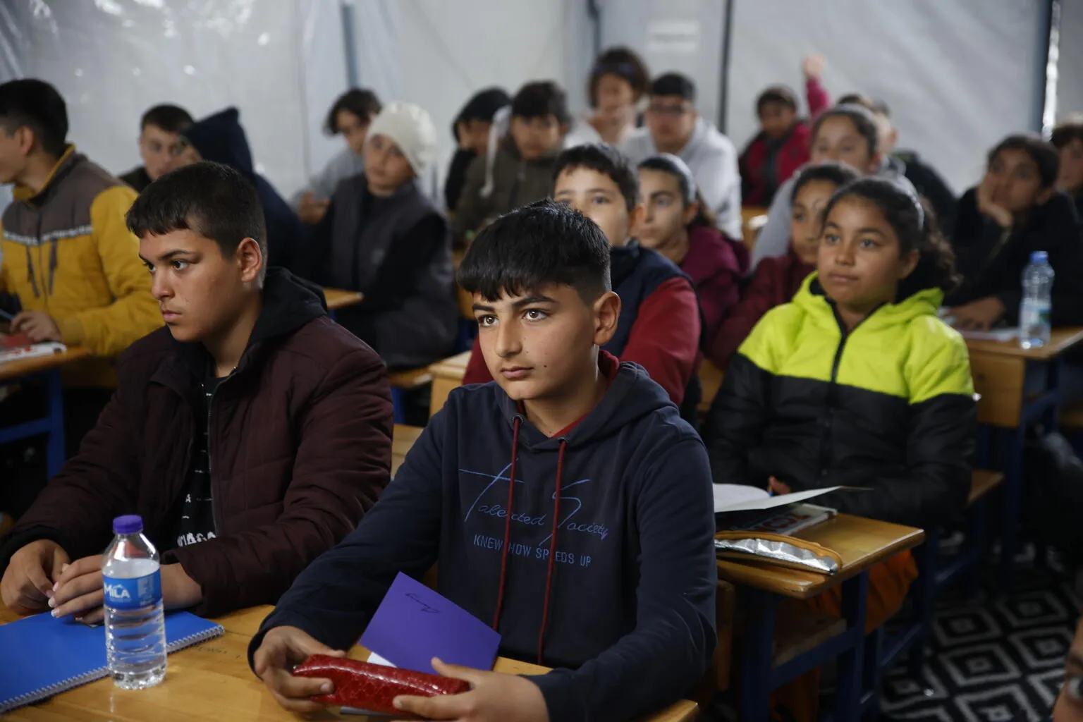 Children attending lessons at a UNICEF-supported tent classroom in a temporary shelter in Antakya, after two devastating earthquakes hit south-east Türkiye.