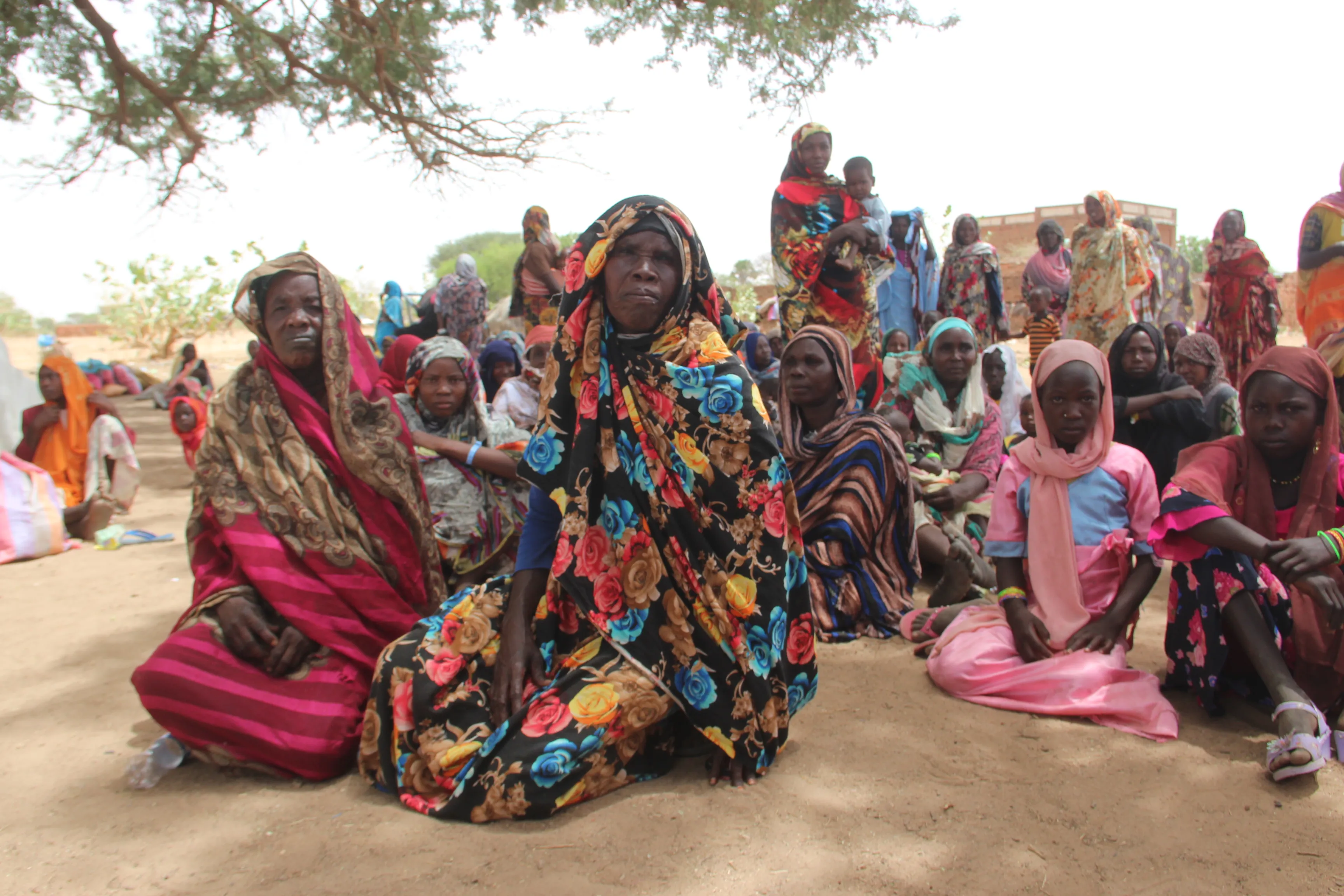 On 27 April 2023, as conflict escalates in Sudan, a group of refugees, mostly women and children, rest under a tree to protect themselves from the high temperatures after crossing into the Chadian village of Koufroun, which is situated on the Chad-Sudan border.