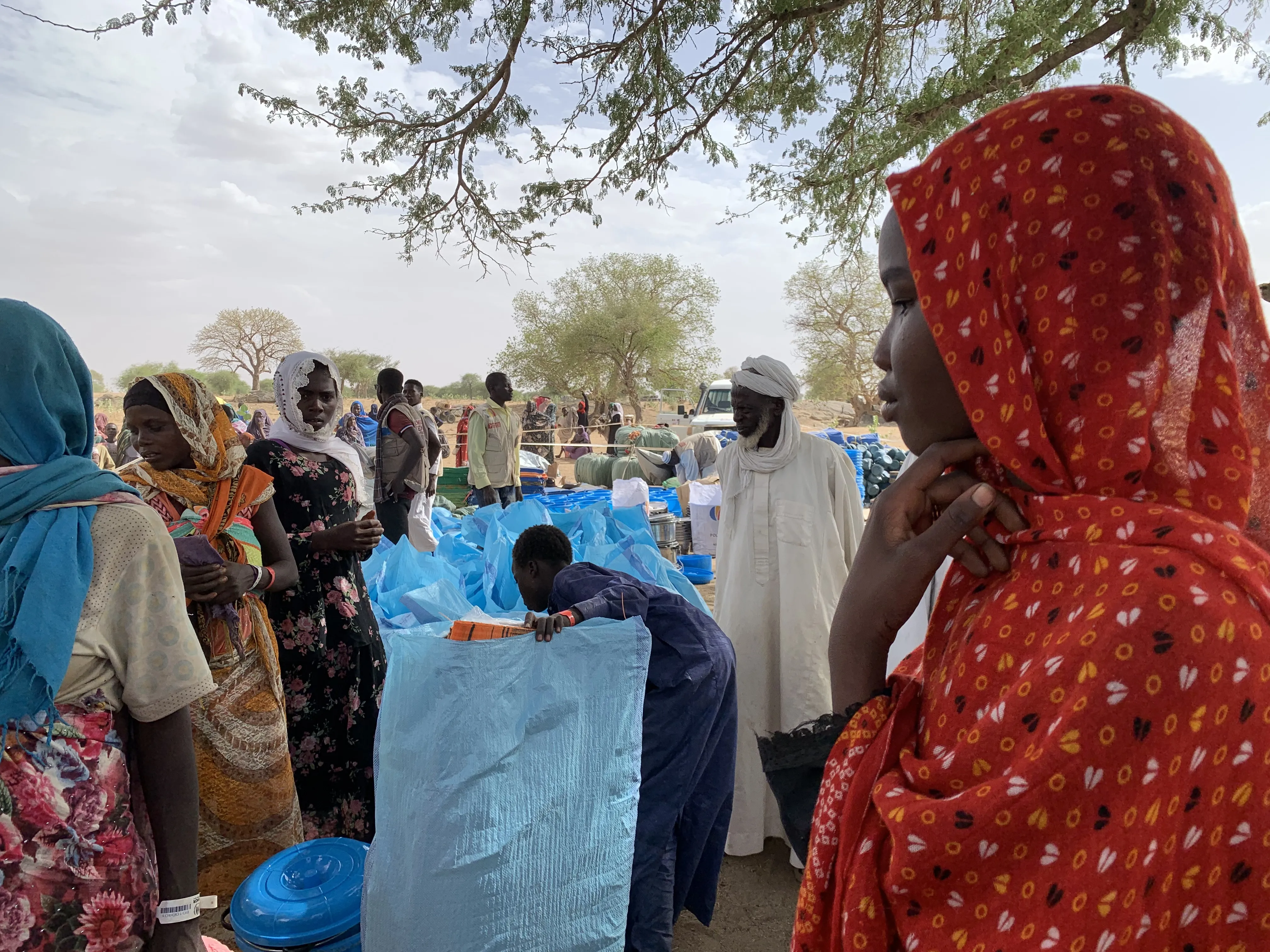 On 30 April 2023, 16-year-old Ikhram, right, waits in line to collect non-food items distributed by UNICEF and its partners in Kounfroun, Chad.