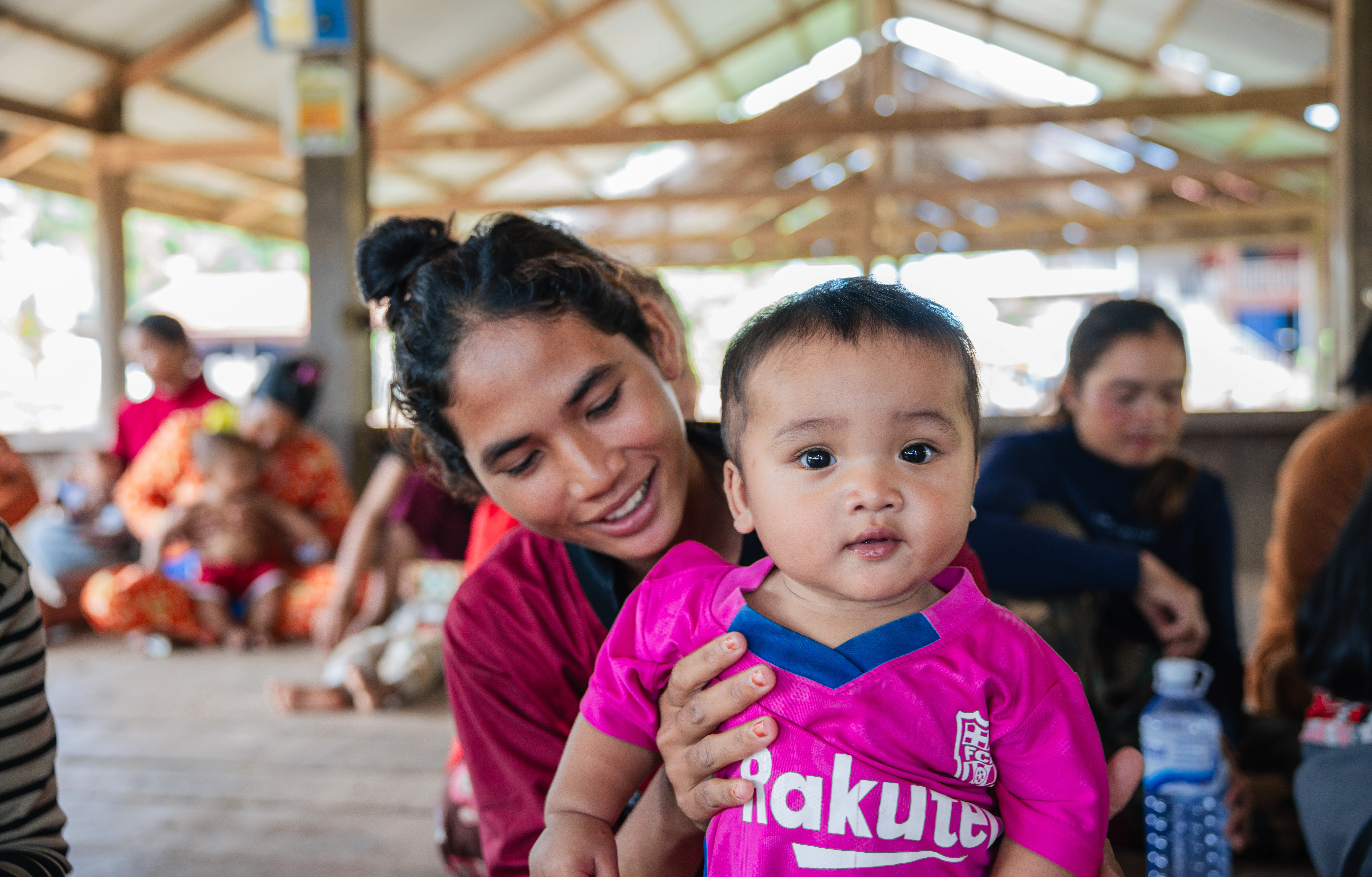 Mother holding her baby at a community vaccination session in Preah Vihear, Cambodia.
