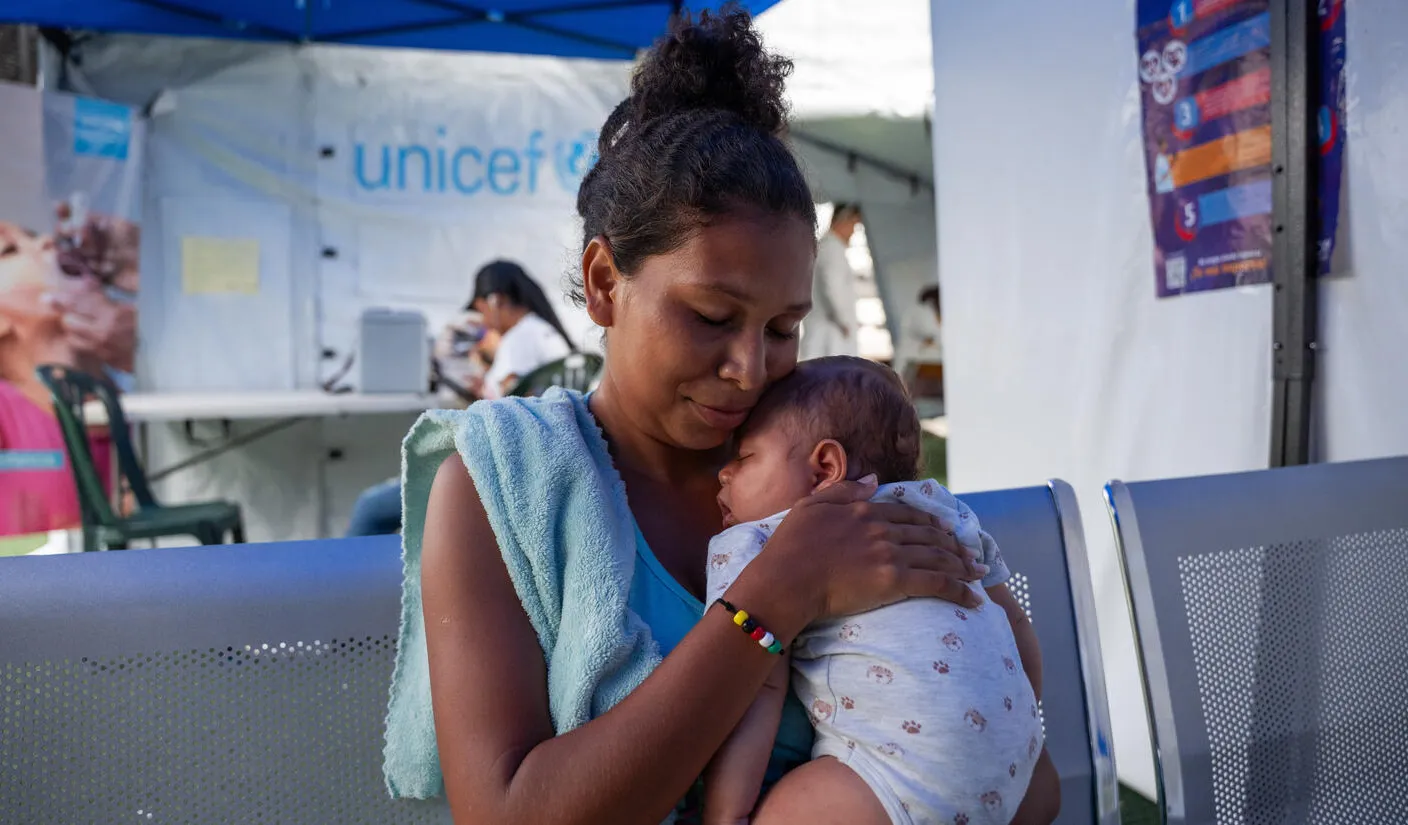 A woman holds a baby at a temporary health clinic. 