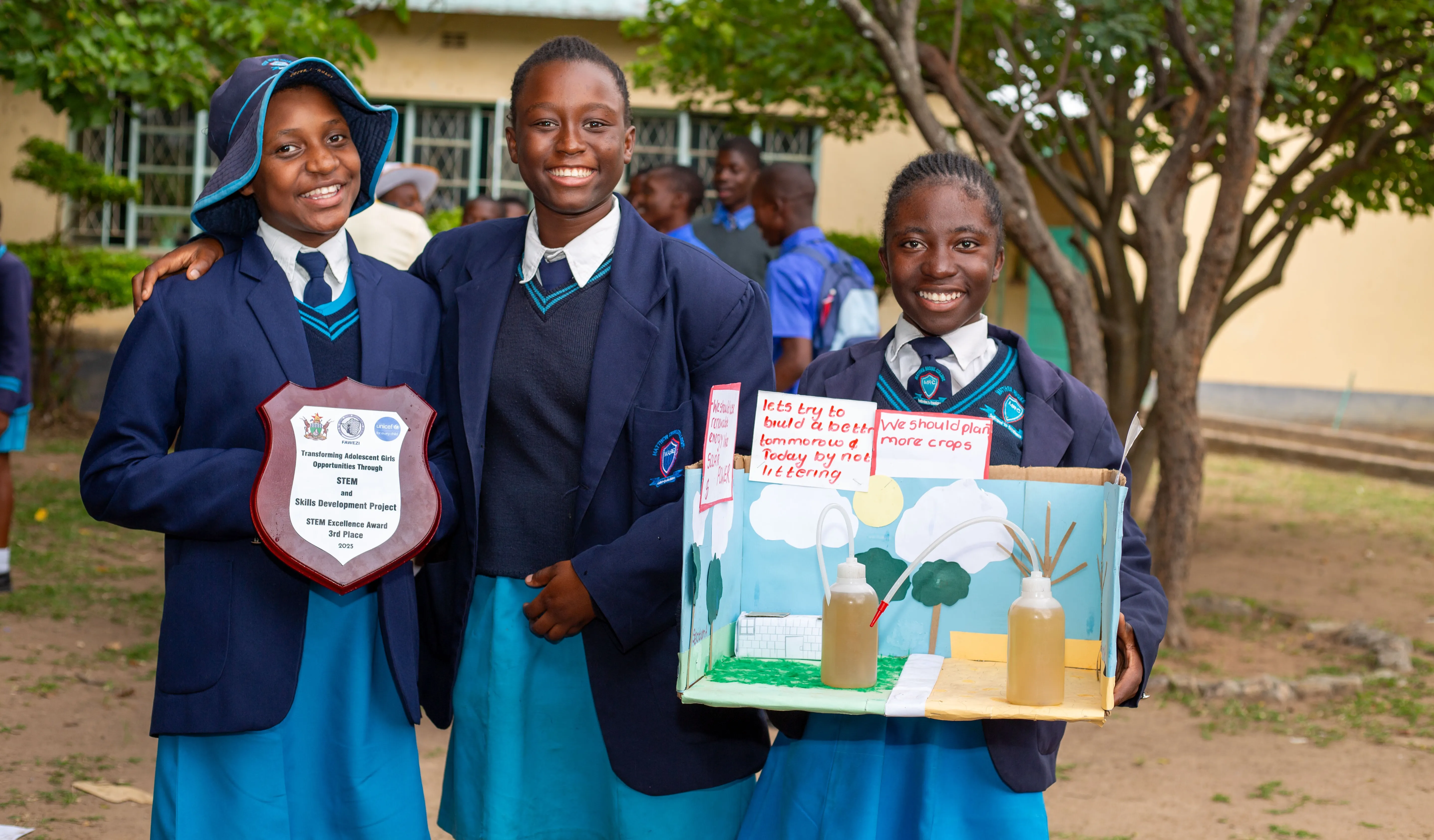 Three girls pose for a photo after winning an award at a STEM fair.