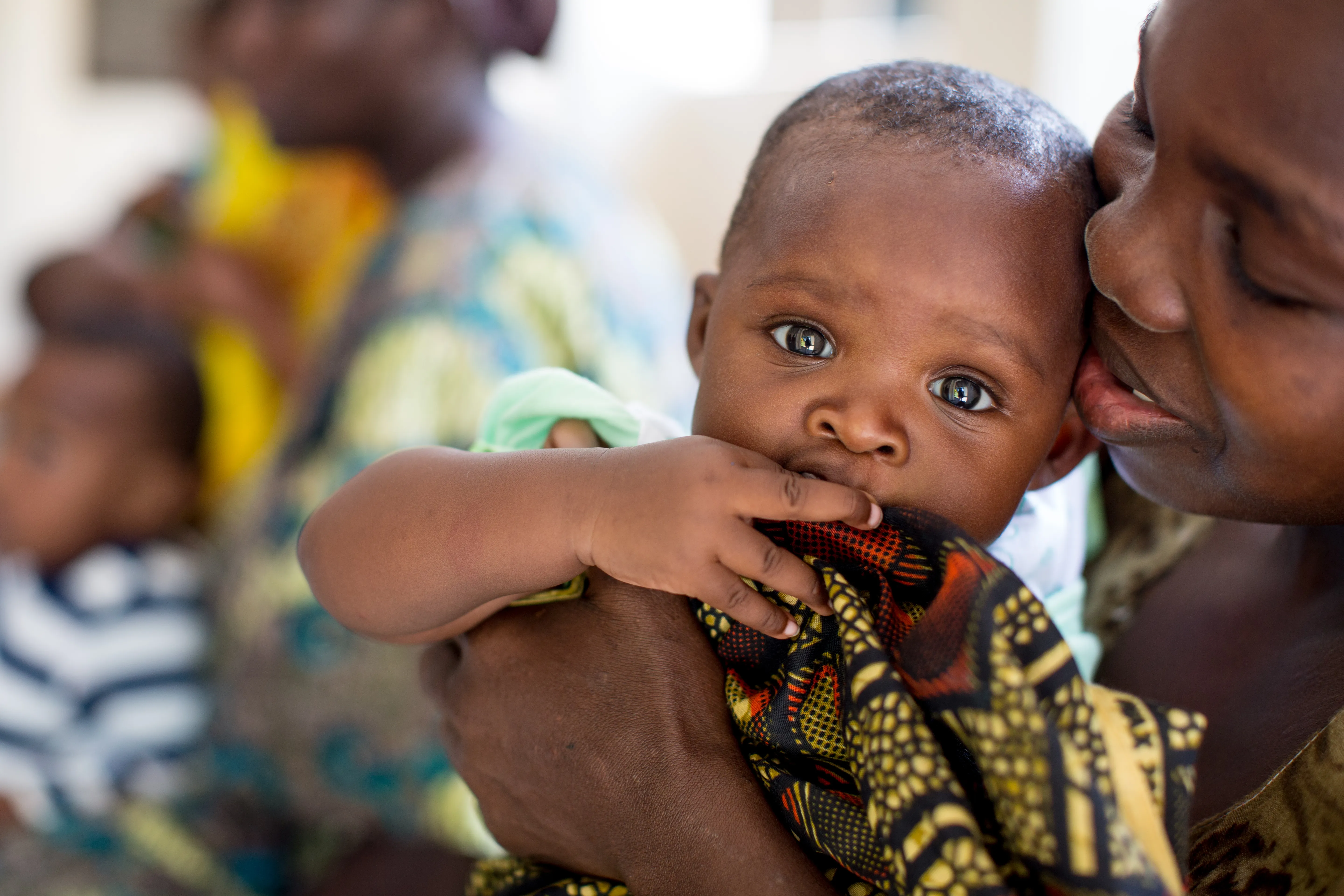 Mother in Tanzania holding her baby close, cheek to cheek.