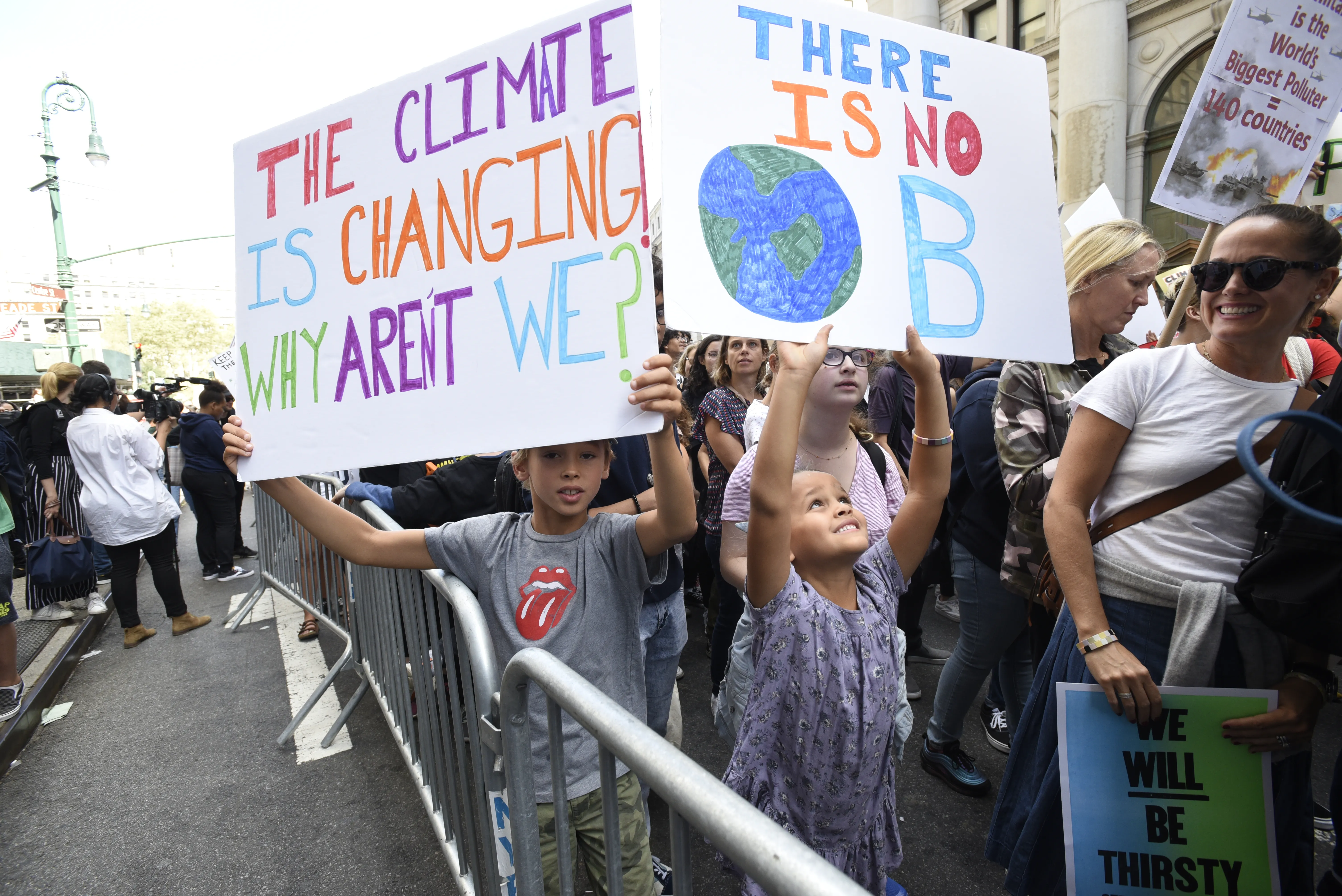 Young people at a climate protest holding placards on climate change.