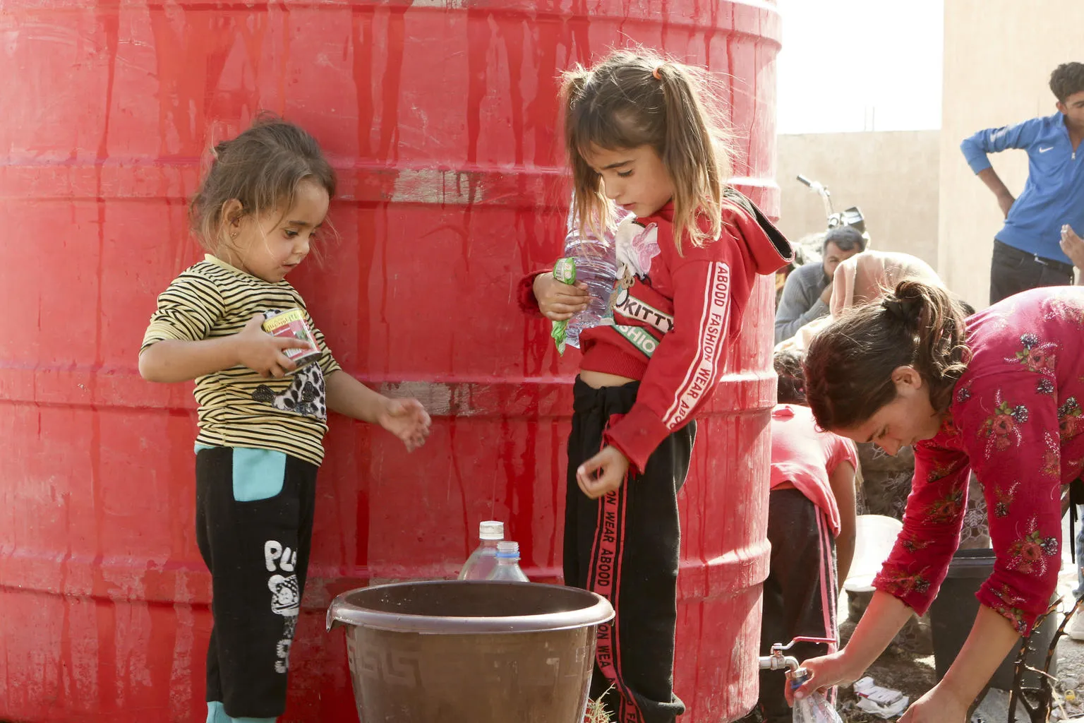 In Syria Two young children wait to fill up a water bucket