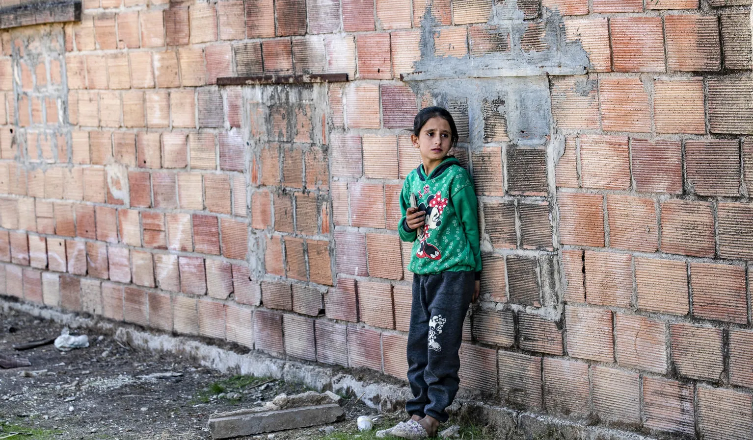A child stands outside the ruins of a building in rural Syria.
