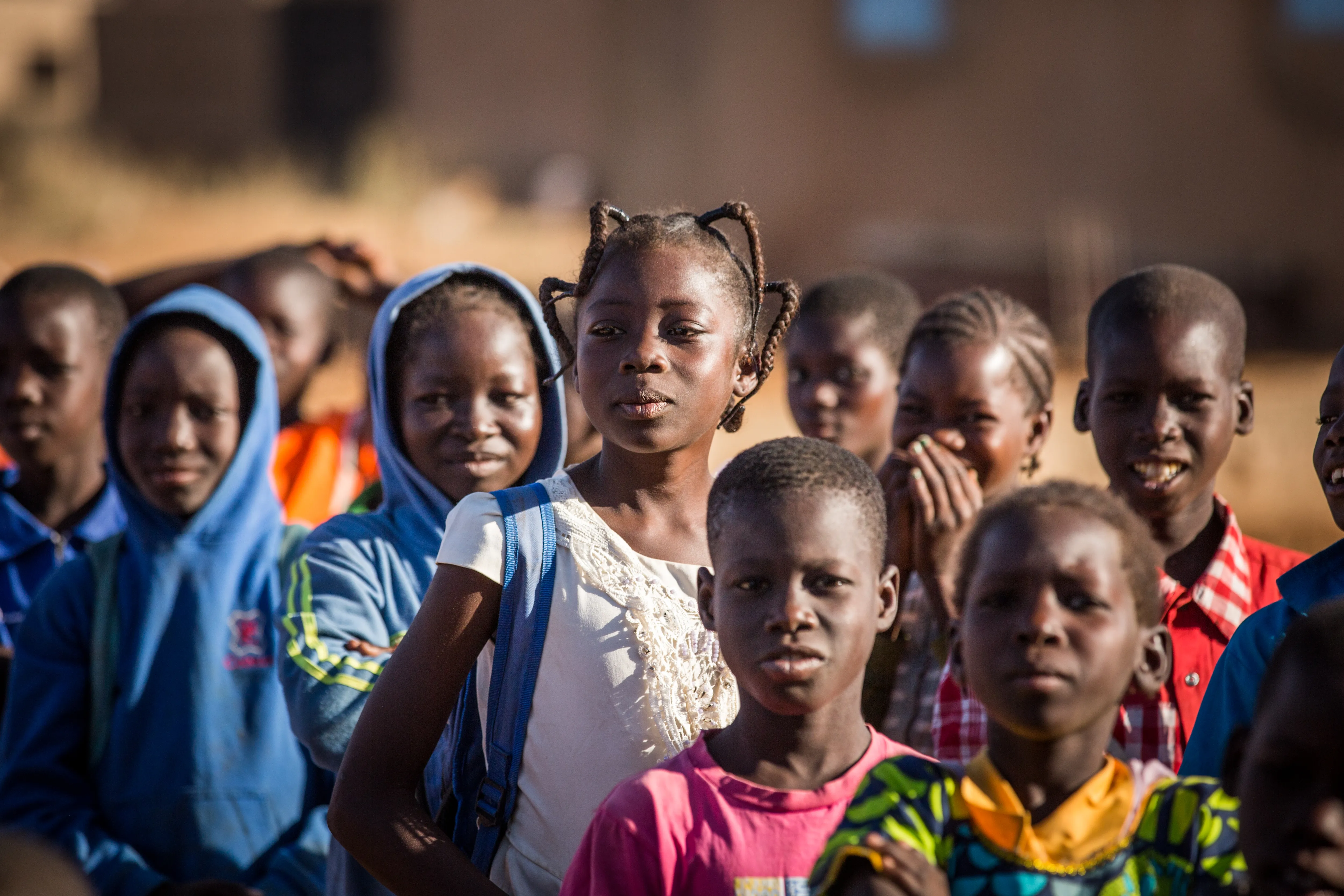 On 3 December 2019, [NAME CHANGED] Nabyla (centre), 13, waits to enter school with her classmates in Kaya, Burkina Faso, the town in which her family found refuge after being displaced. 