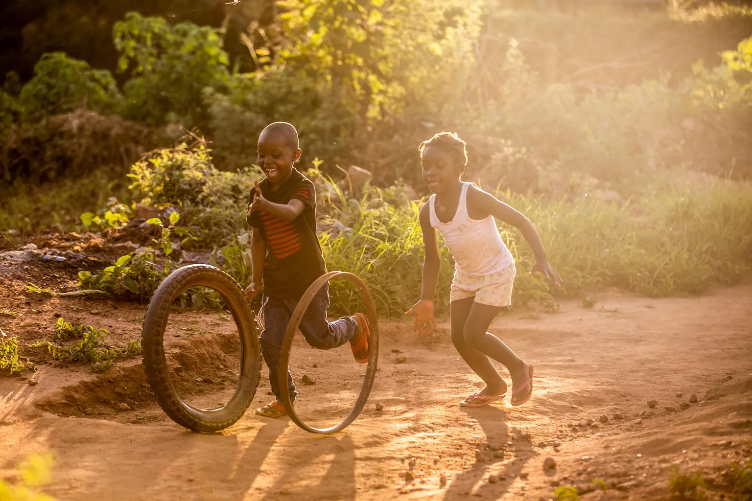 Maria and her friend play as the sun sets in Zambia. Her father Clement, receives UNICEF-supported cash transfers, which help him give her nourishment and protection