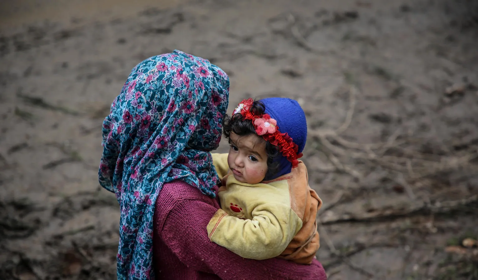 A girl carries a baby in northwest Syria.