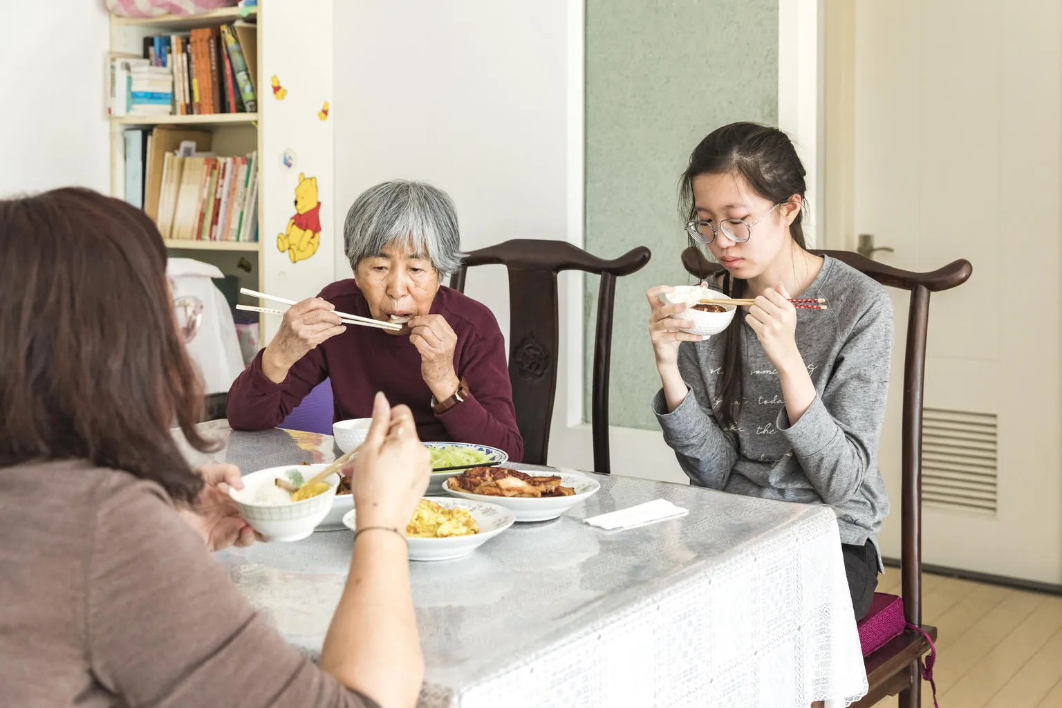 A girl in Beijing eats lunch with her family.