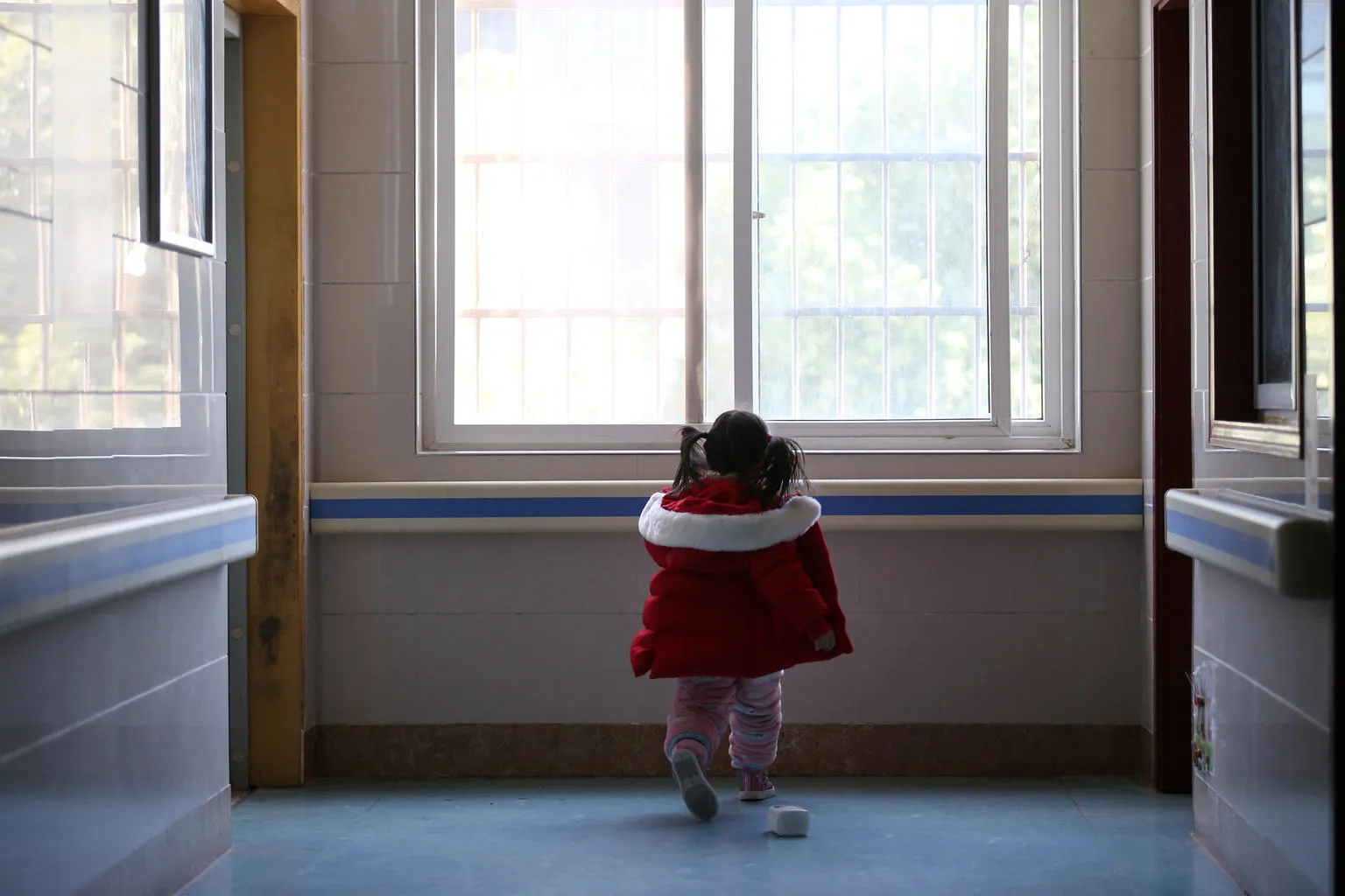 A little girl stands in a hospital ward in Wuhan, China.