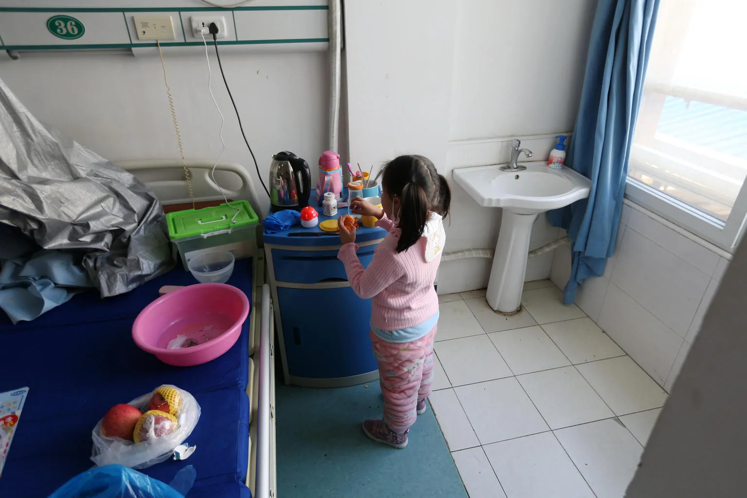 Yuanyuan washes her hands in the hospital ward where she is currently under isolation.