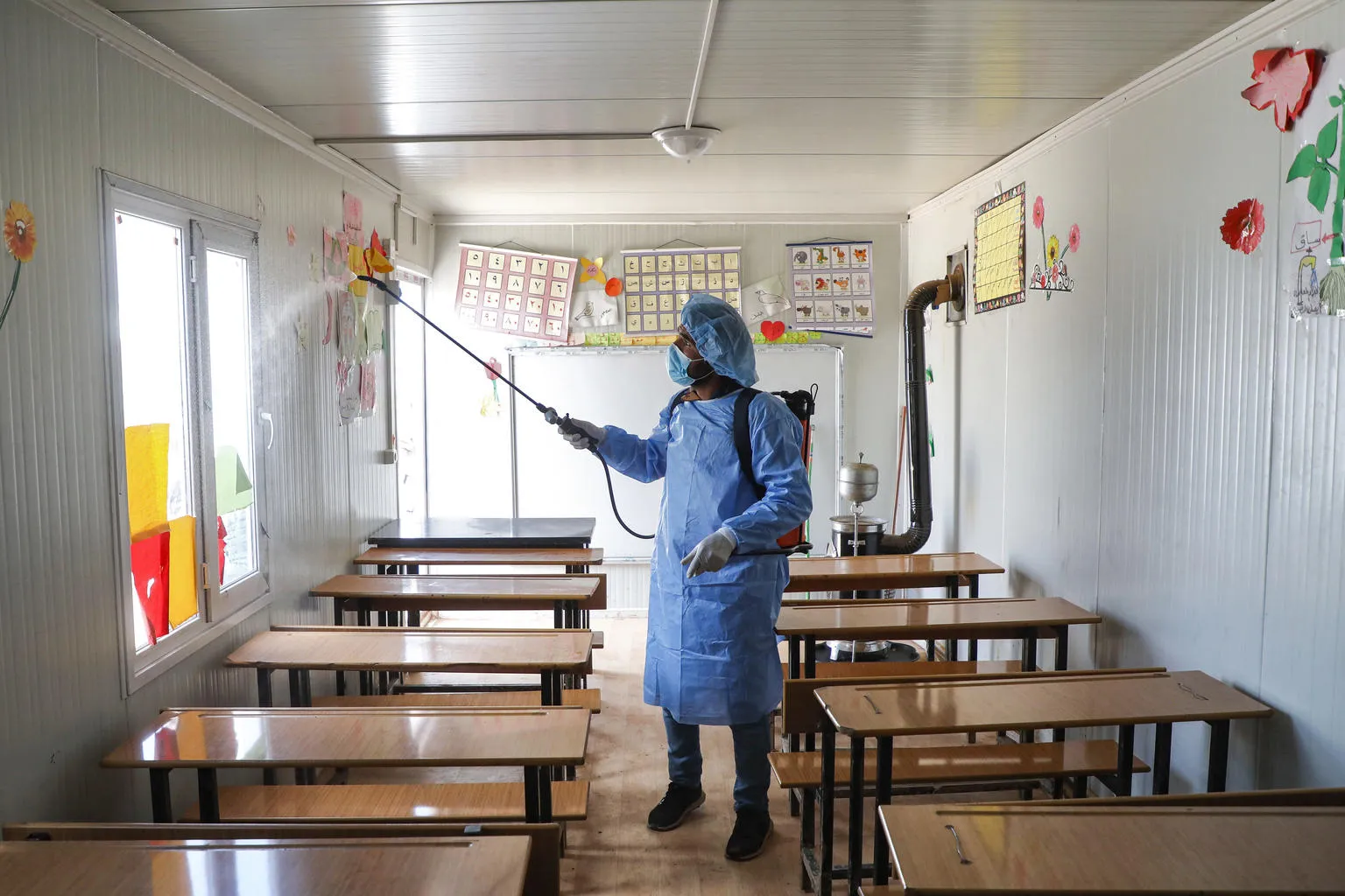  A Syrian volunteer disinfects a classroom in rural Idlib.