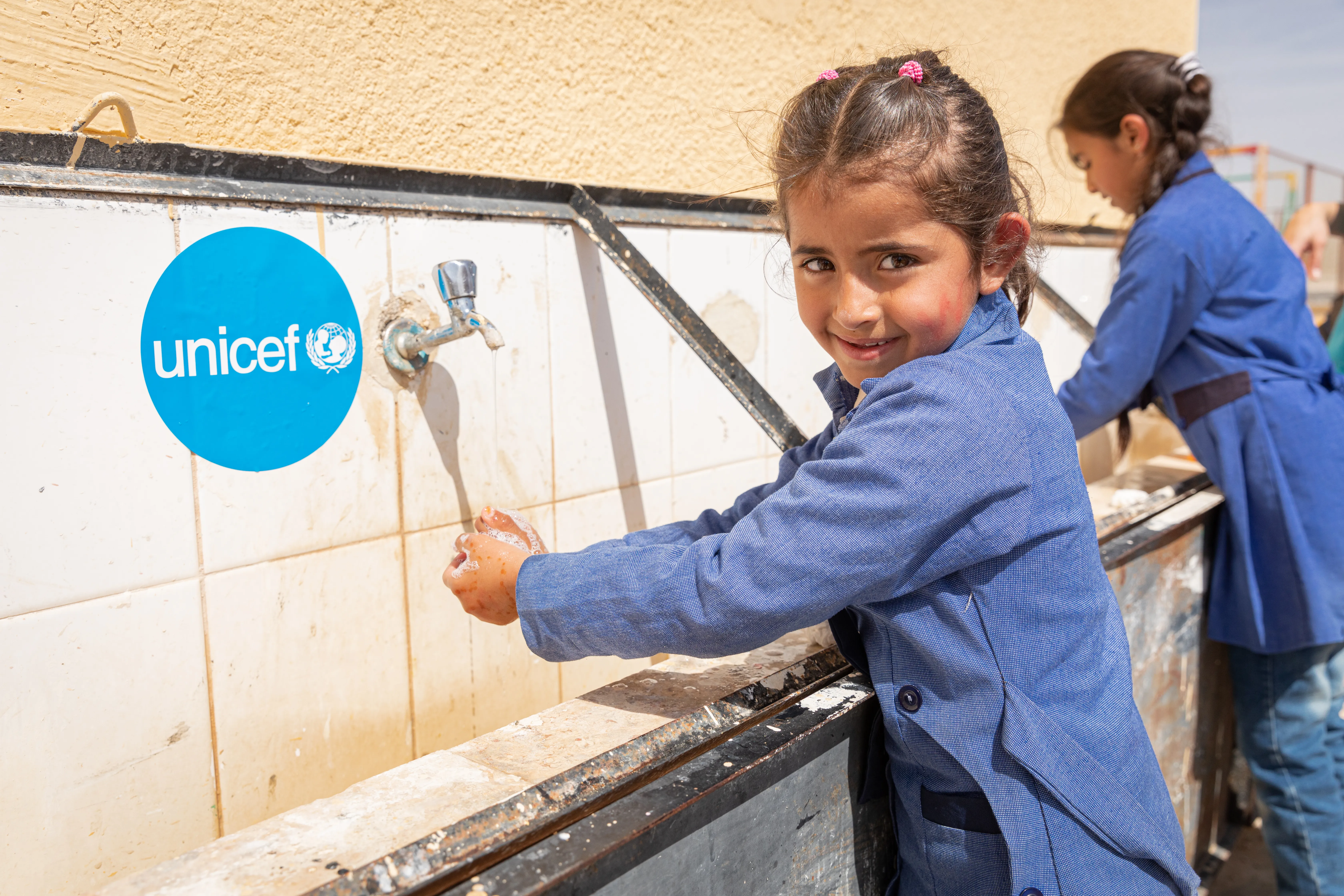 Children in Al Khader mixed primary school take part in a handwashing demonstration.  The students have been receiving and practicing hygiene promotion for three months. It can be difficult, the Principal explains, to find space in a tight school budget to spend on hygiene materials or infrastructure – even purchasing soap for the 67 students in this rural area can be a struggle.