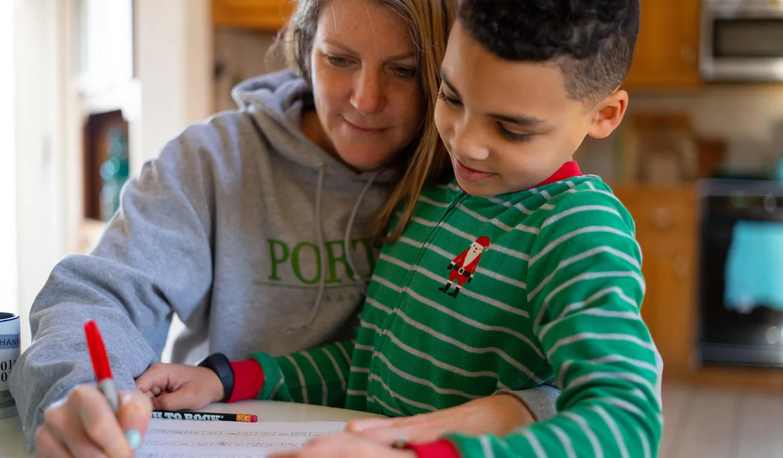 A child and mother study together at home.